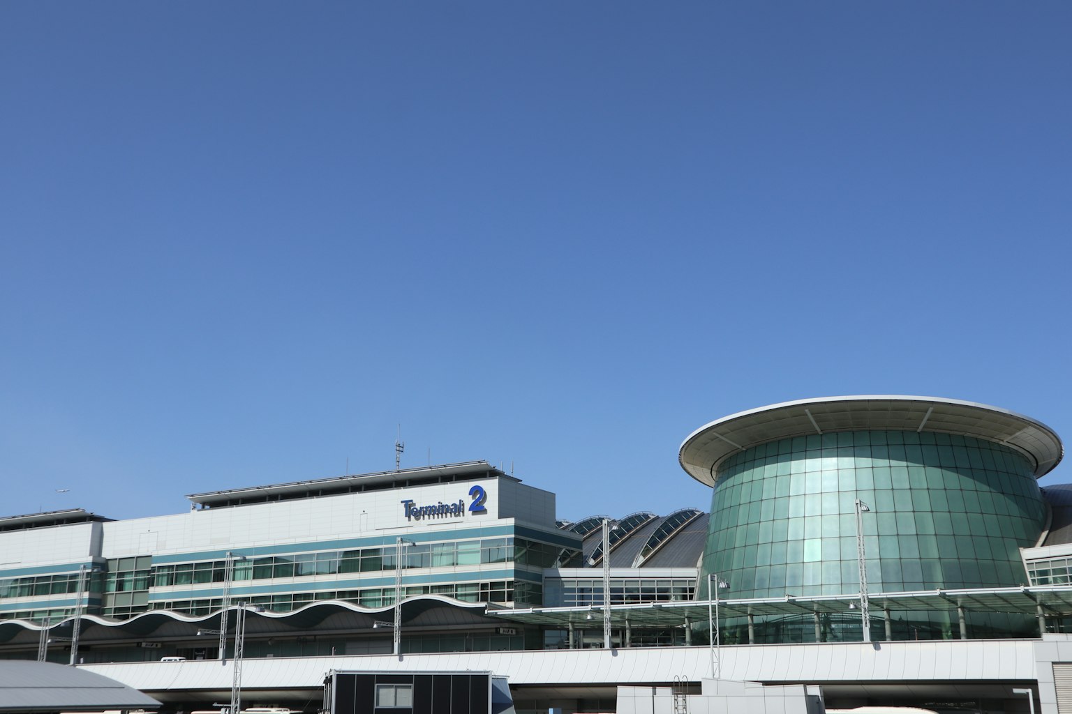 Exterior view of New Chitose Airport terminal building with clear blue sky
