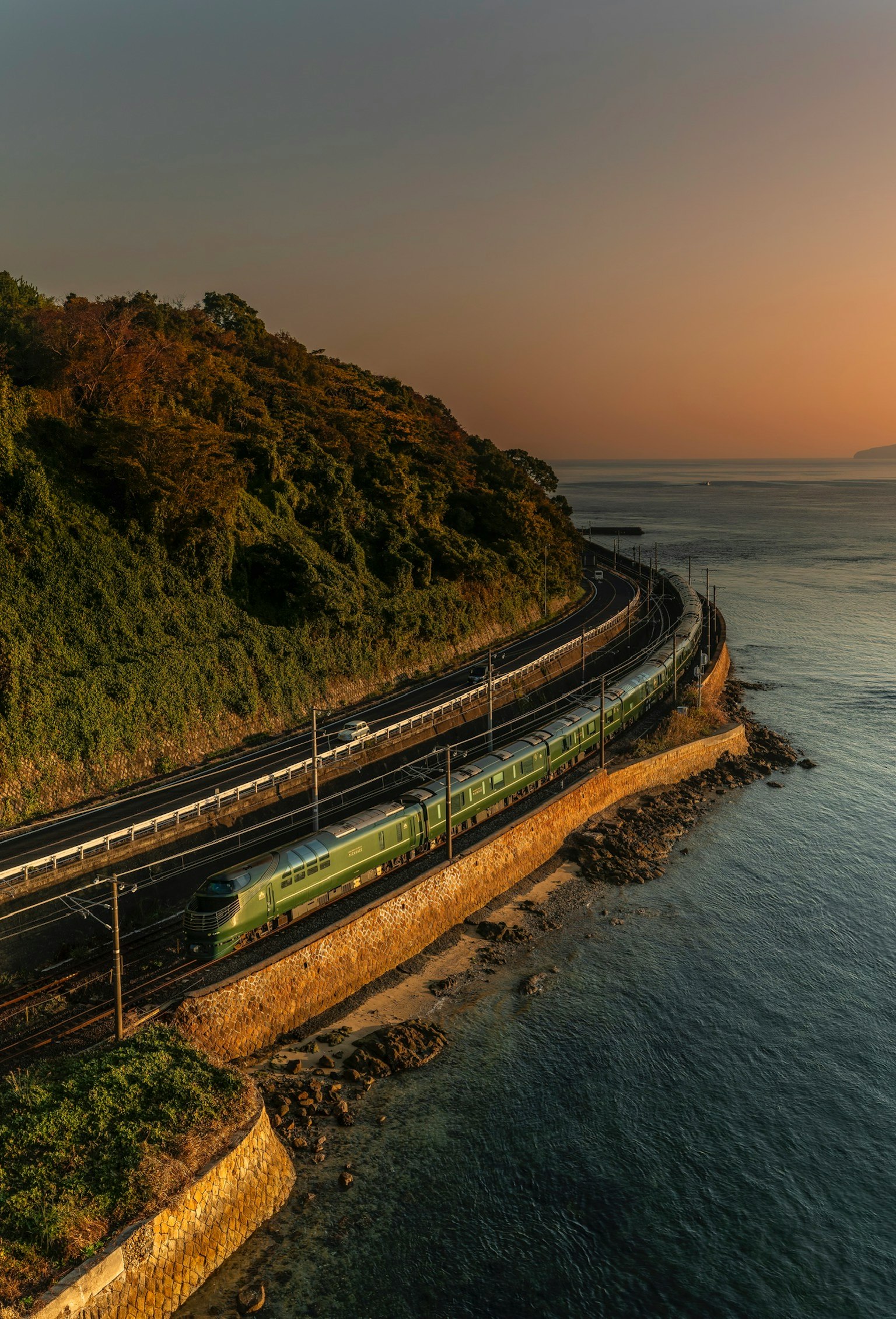 海に沿った曲がりくねった鉄道と夕焼けの風景