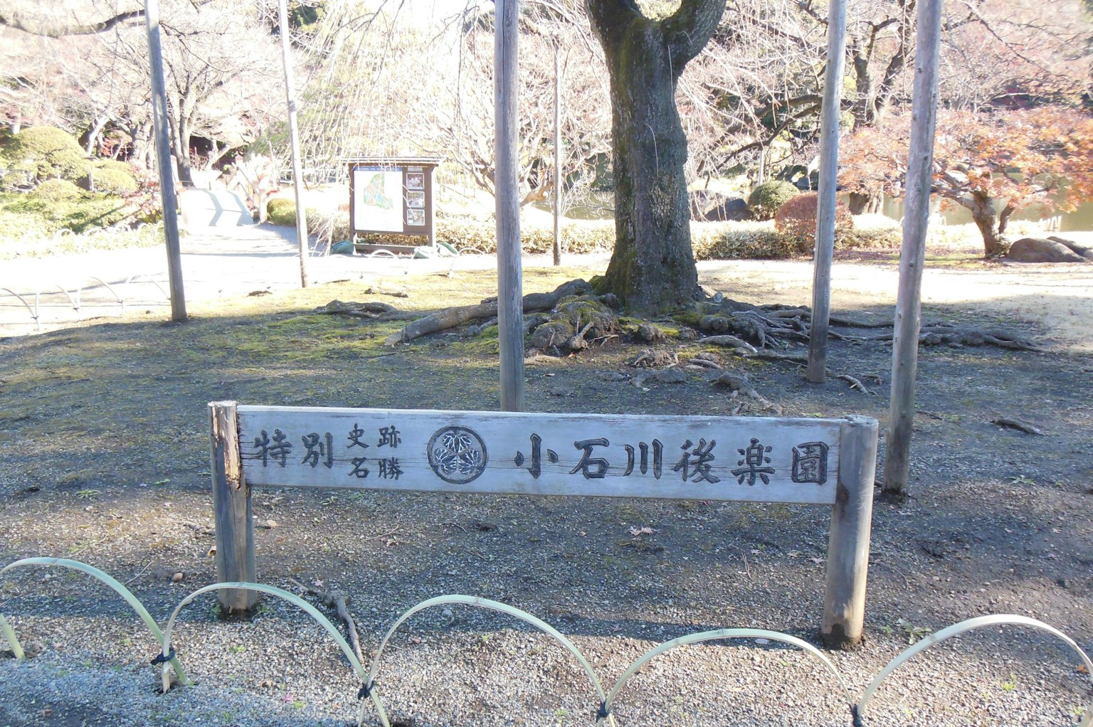 Park view featuring a sign for Koishikawa Korakuen