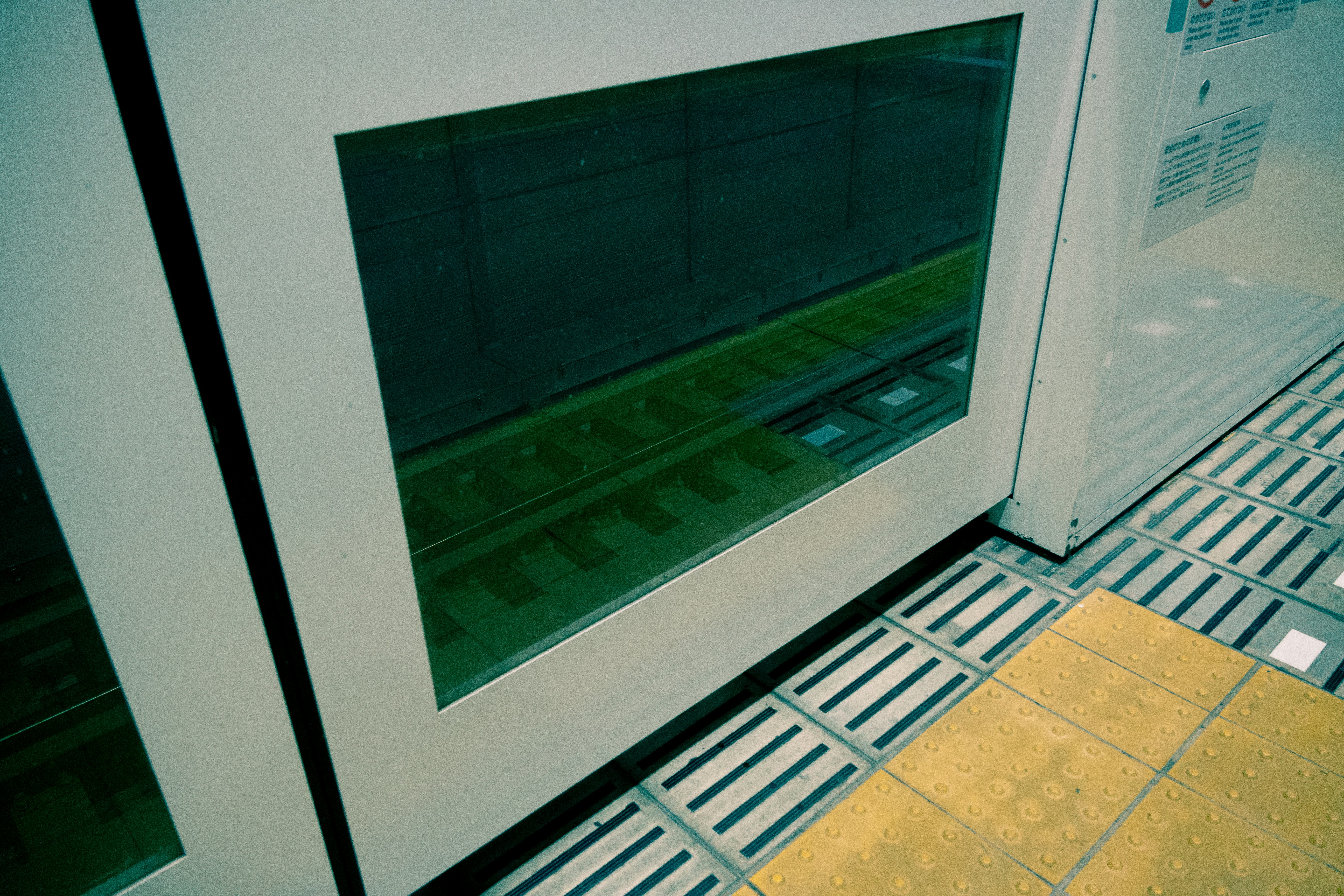 緑の画面が表示された機器と床の点字ブロック