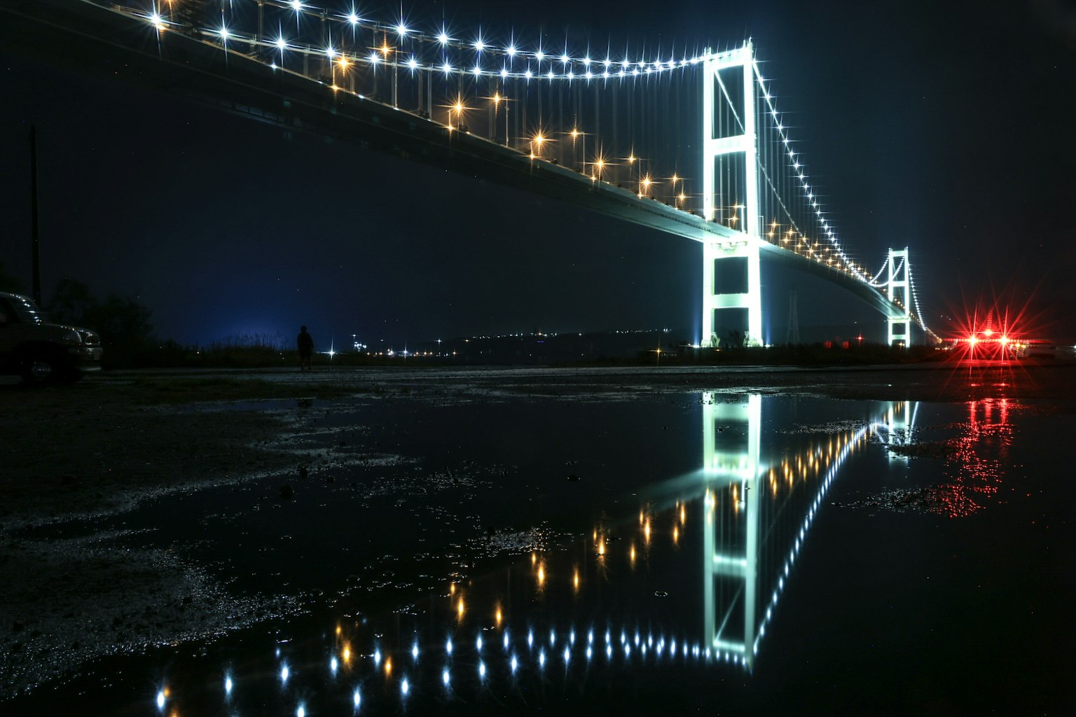 Beautifully lit bridge at night with reflections on water