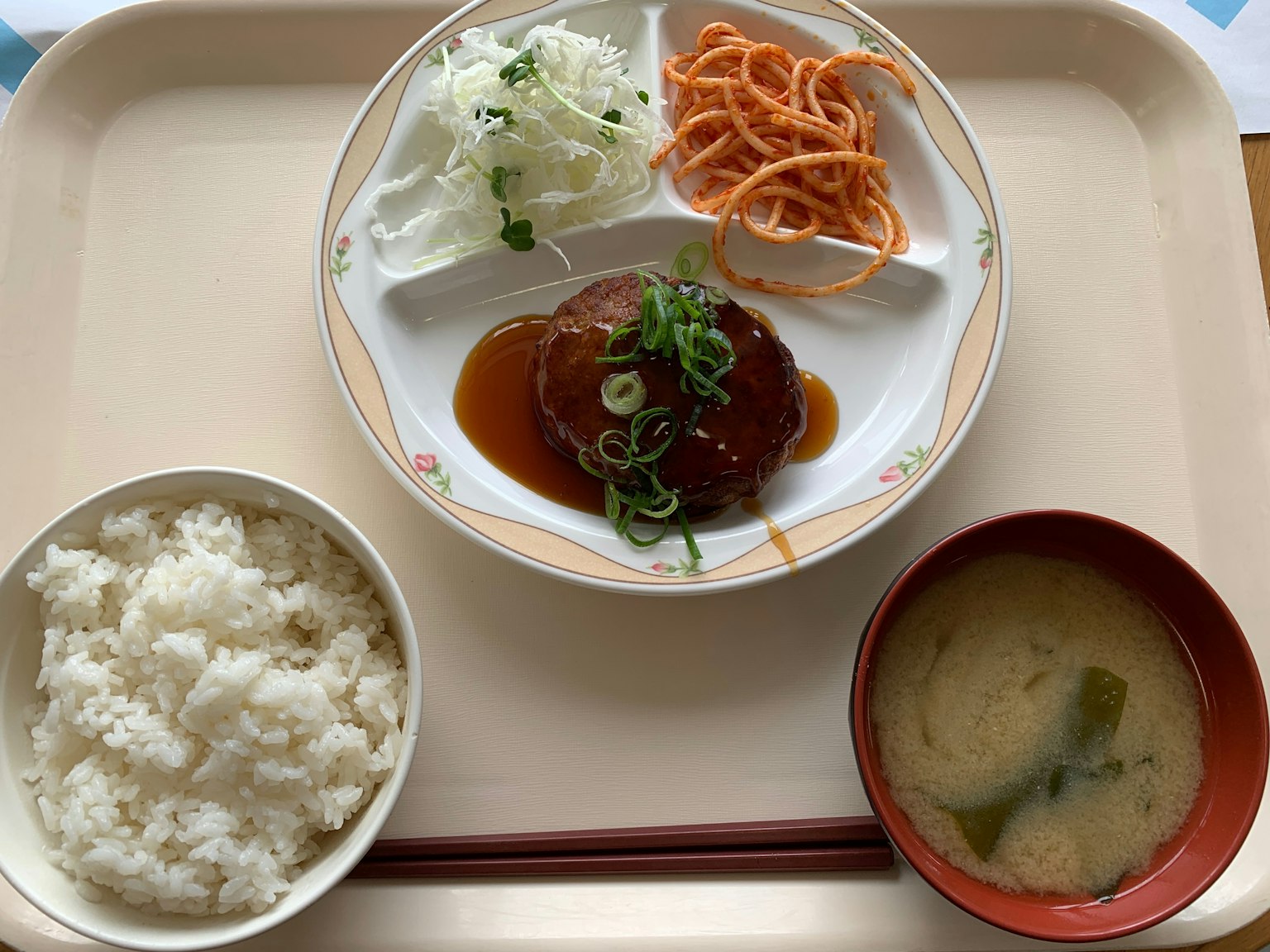 Tablett mit Reis, Miso-Suppe, Hamburgersteak, gehacktem Kohl und Spaghetti-Salat