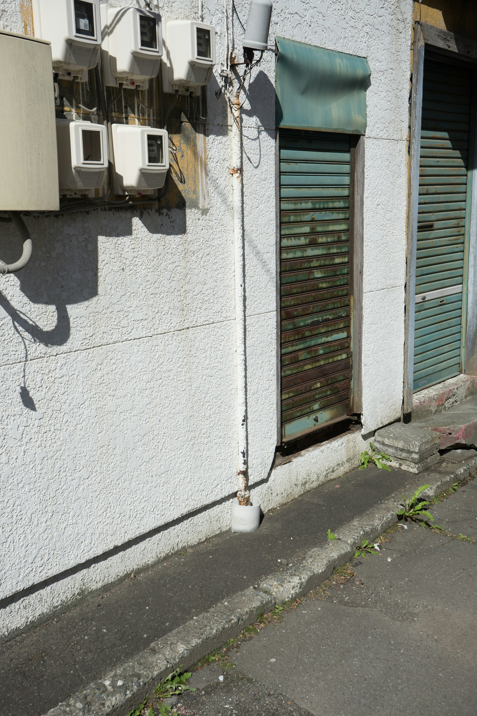 Parte di un muro con una vecchia saracinesca e unità di climatizzazione
