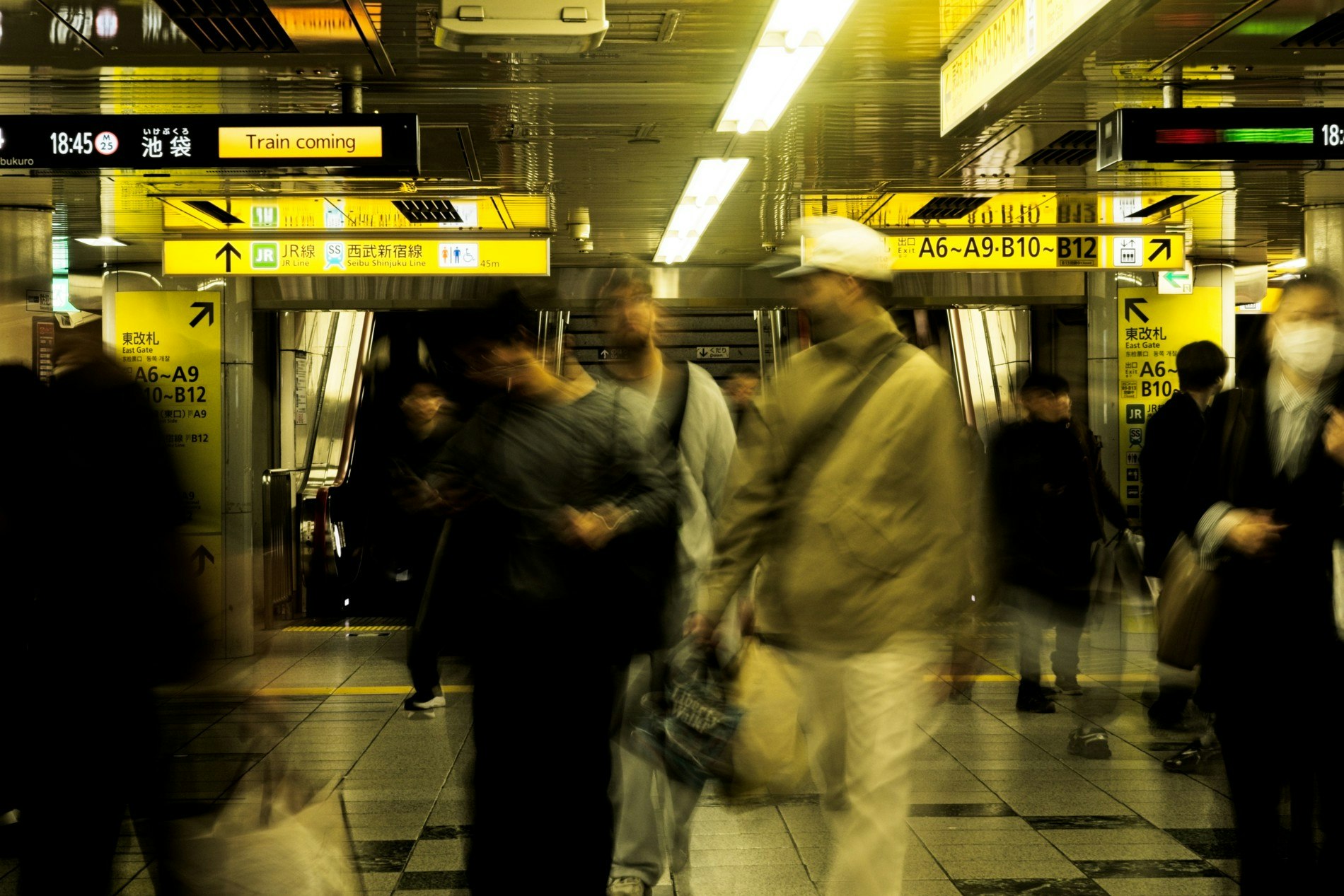 駅構内のホームで人が行き交う改札付近の風景