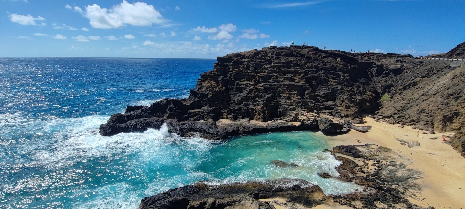 Vue côtière pittoresque avec océan bleu formations rocheuses et plage de sable