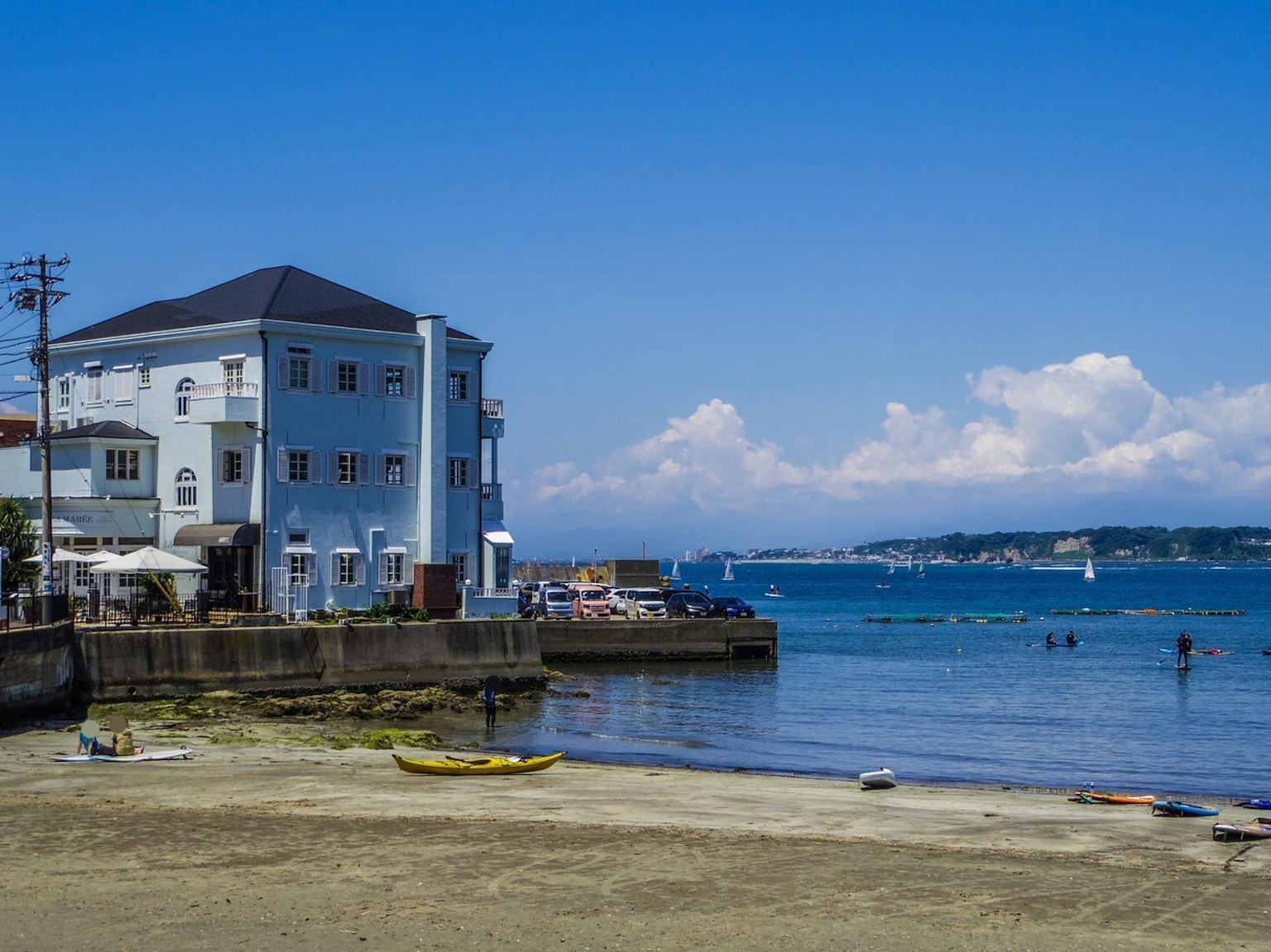 Scenic beach view featuring a blue sea and a white building