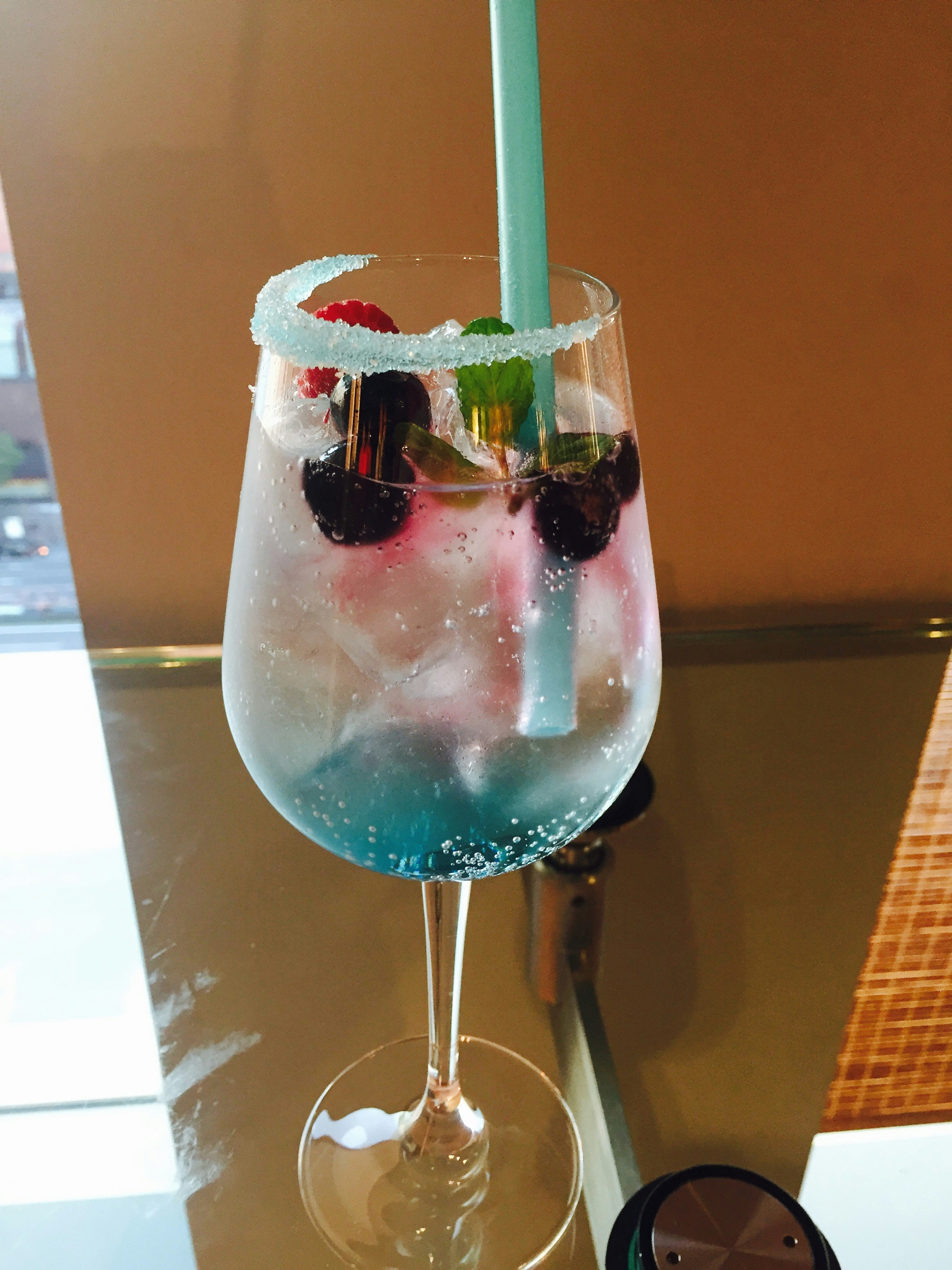 酒吧裡藍色雞尾酒杯，冰塊與氣泡