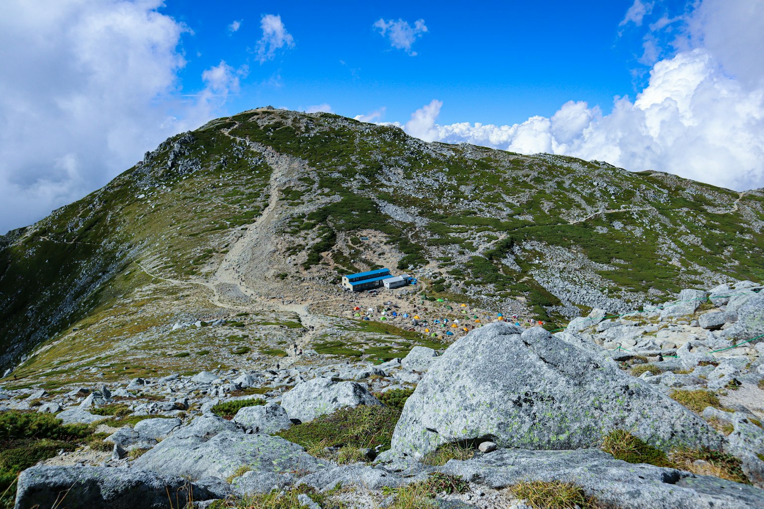 Paesaggio montano con una cabina blu e terreno roccioso