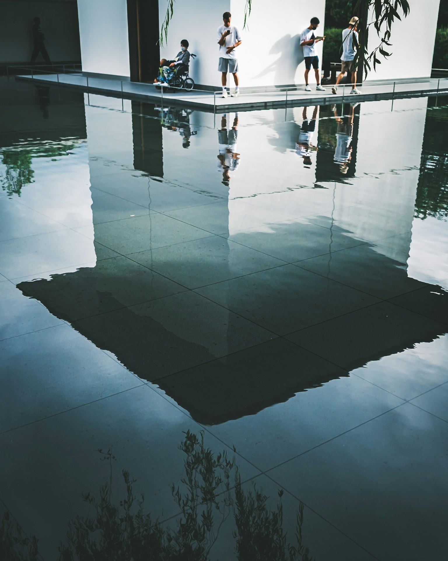 Bâtiment moderne reflété dans l'eau avec des personnes