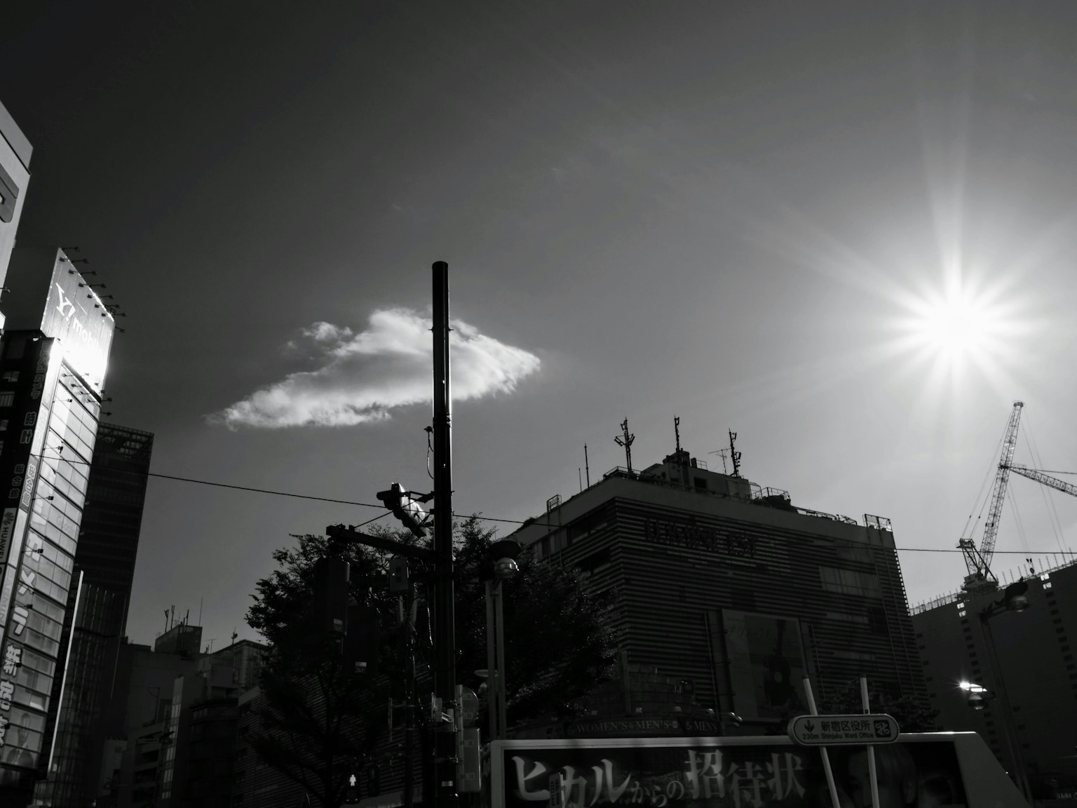 Paesaggio urbano in bianco e nero con una nuvola e la luce del sole
