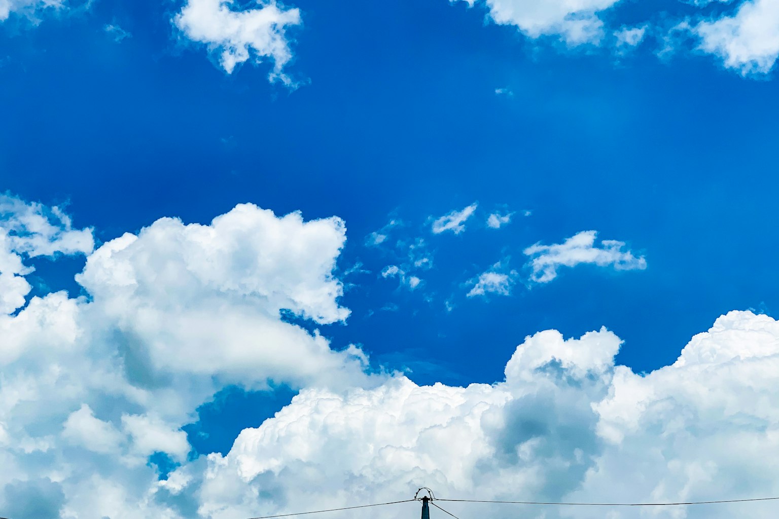 Un paysage d'un ciel bleu avec des nuages blancs et duveteux