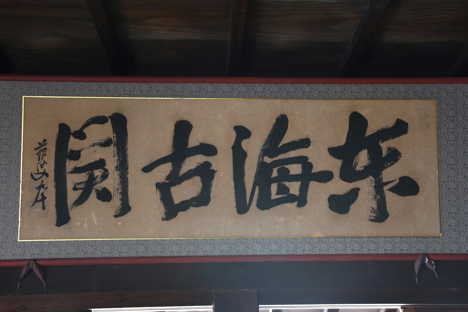 Papan dengan karakter Cina dalam kaligrafi tradisional