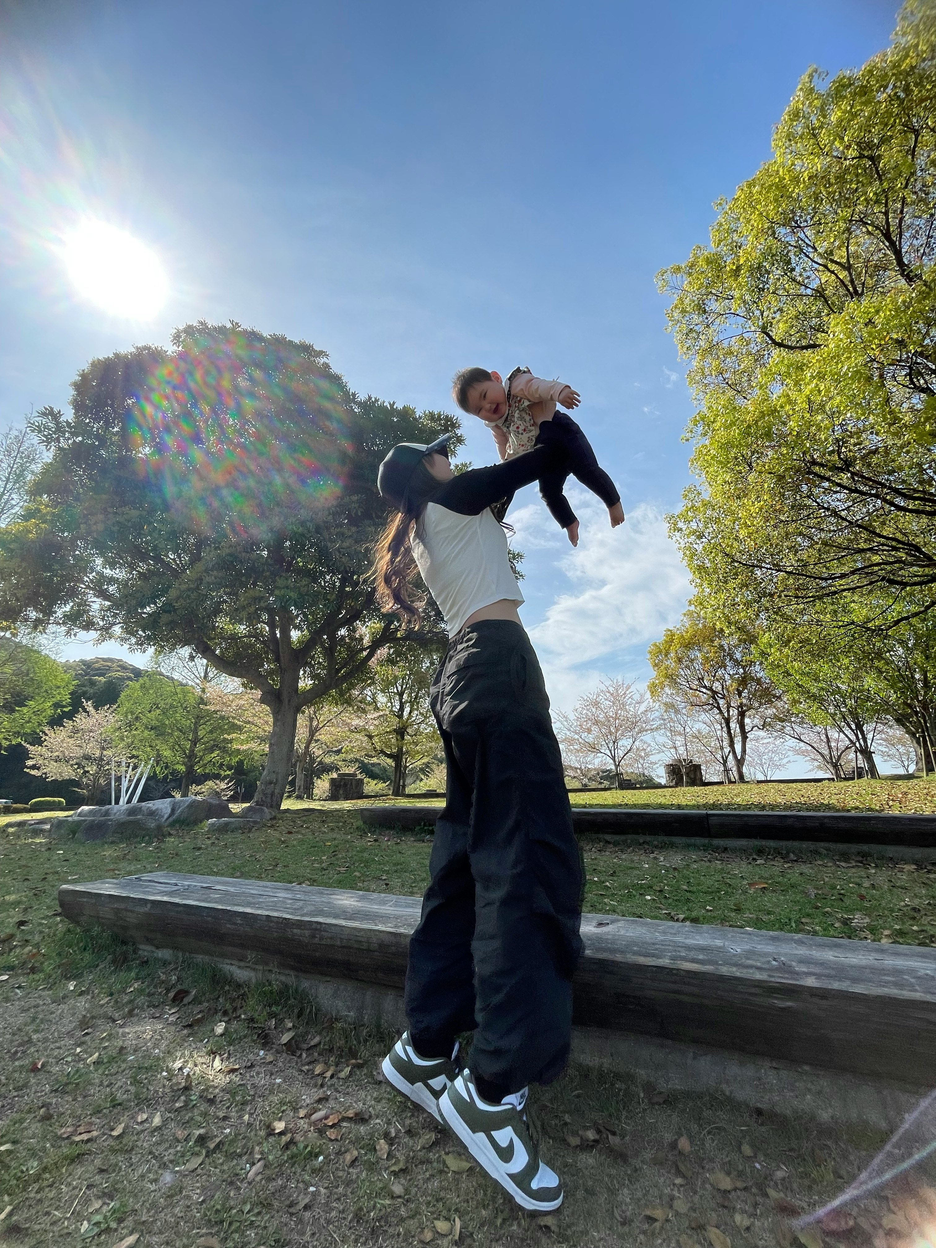 公園の芝生でポーズをとる親子