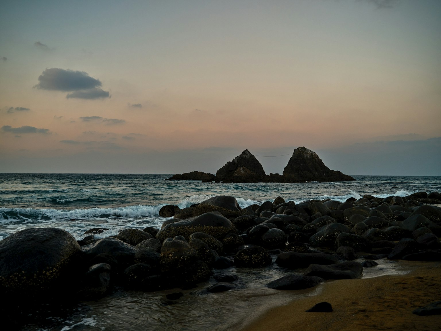 ชายหาดหินในยามพลบค่ำกับหินเด่นสองก้อน