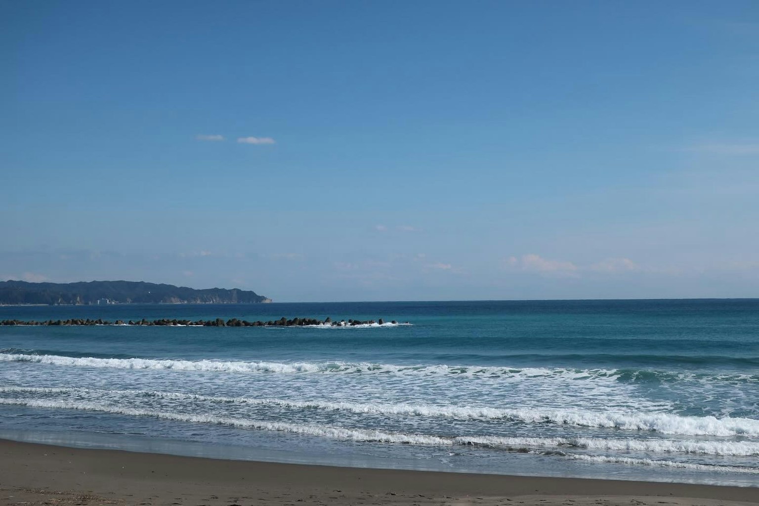 Vista panoramica dell'oceano blu e del cielo con onde che si infrangono sulla riva