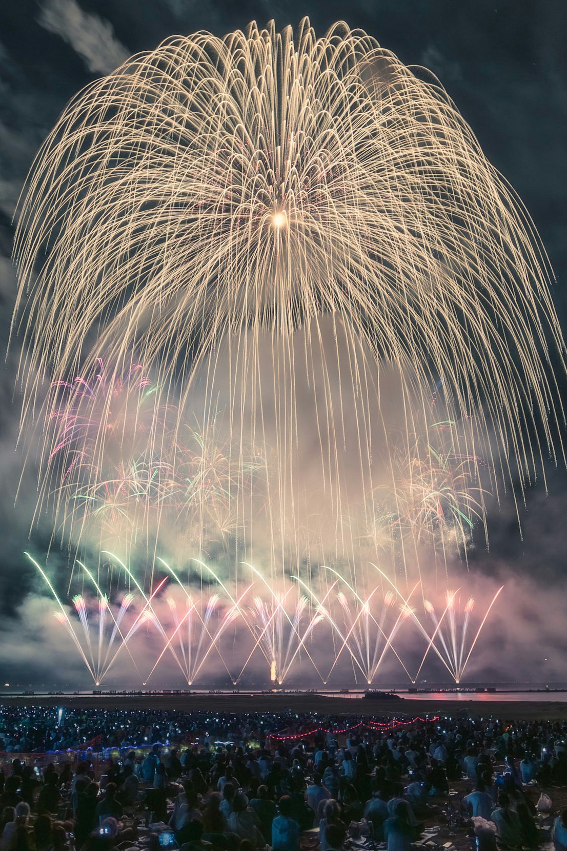 花火が打ち上がる夜空と観客の群衆