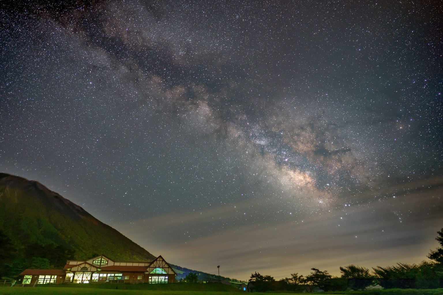 Ciel nocturne magnifique avec une galaxie et la silhouette d'une montagne