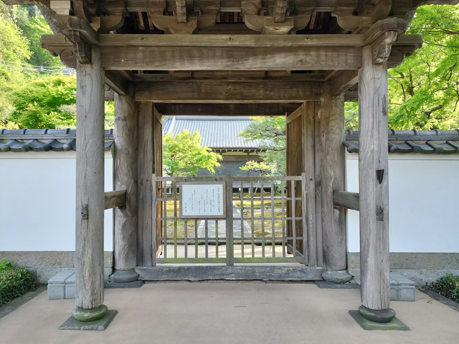Holztür mit weißen Wänden am Eingang eines japanischen Gartens