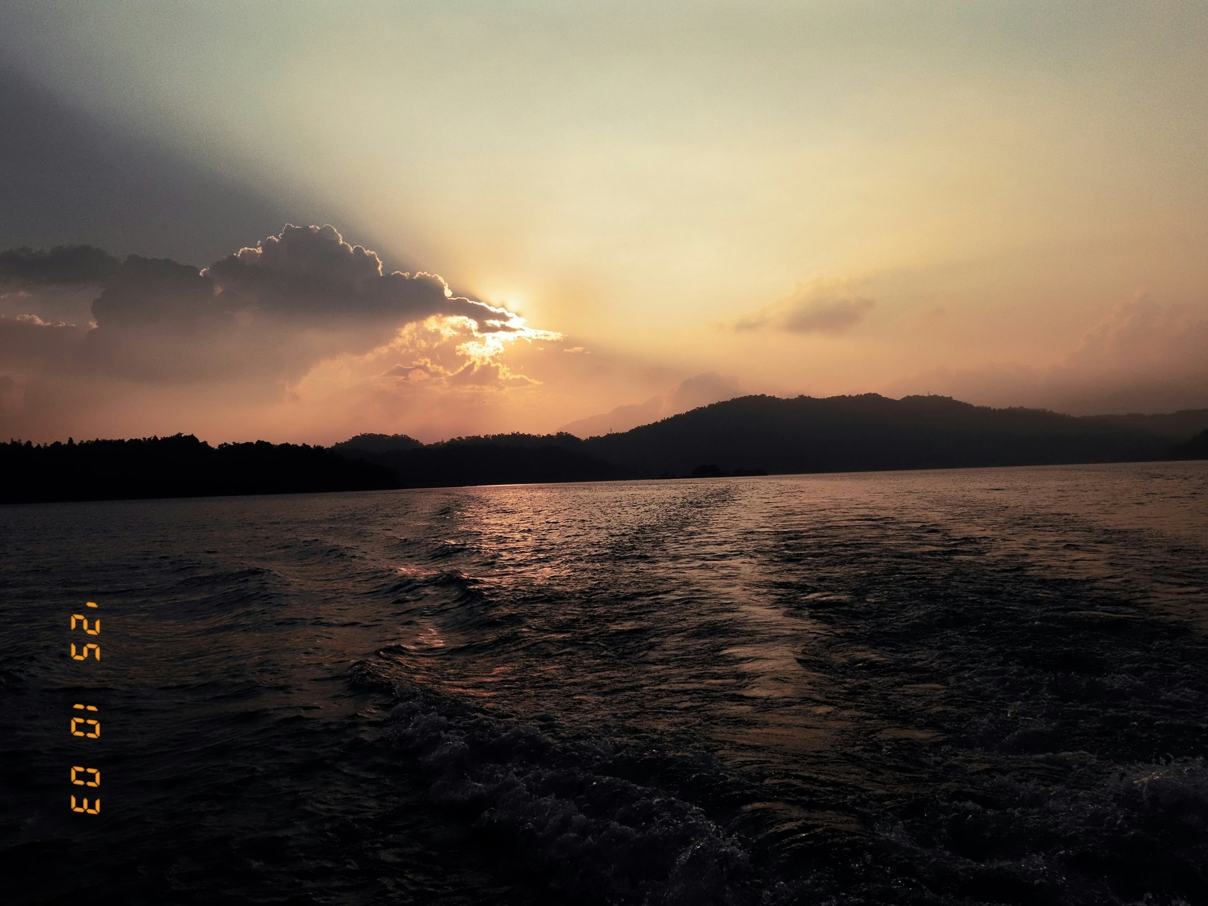 夕暮れの湖面に広がる水平線と雲のある風景
