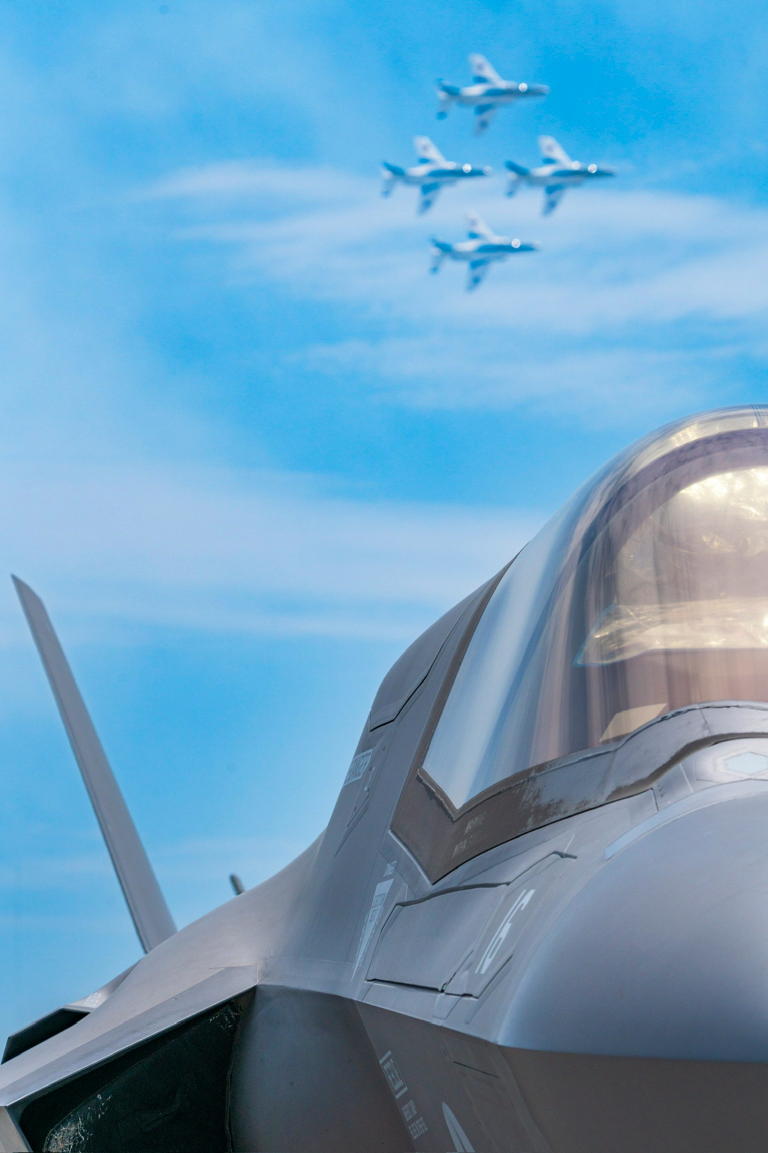 Gros plan d'un avion de chasse avec une formation d'avions dans le ciel bleu
