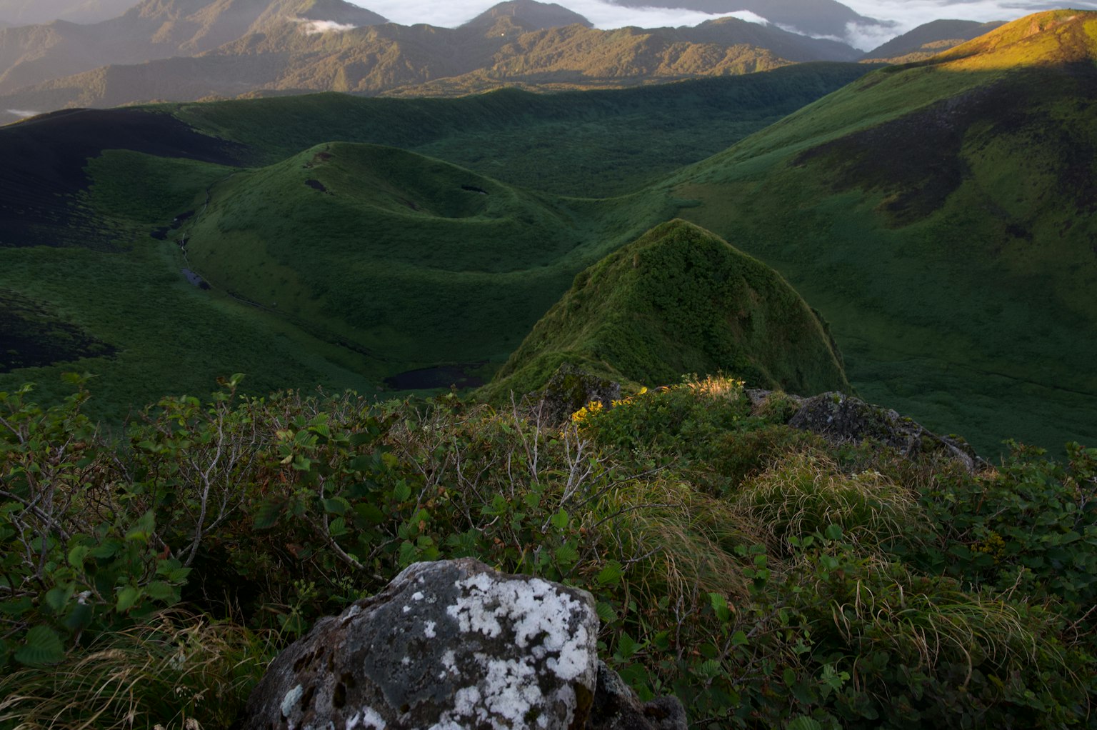 Vista panoramica di colline verdi e rocce in un paesaggio montano