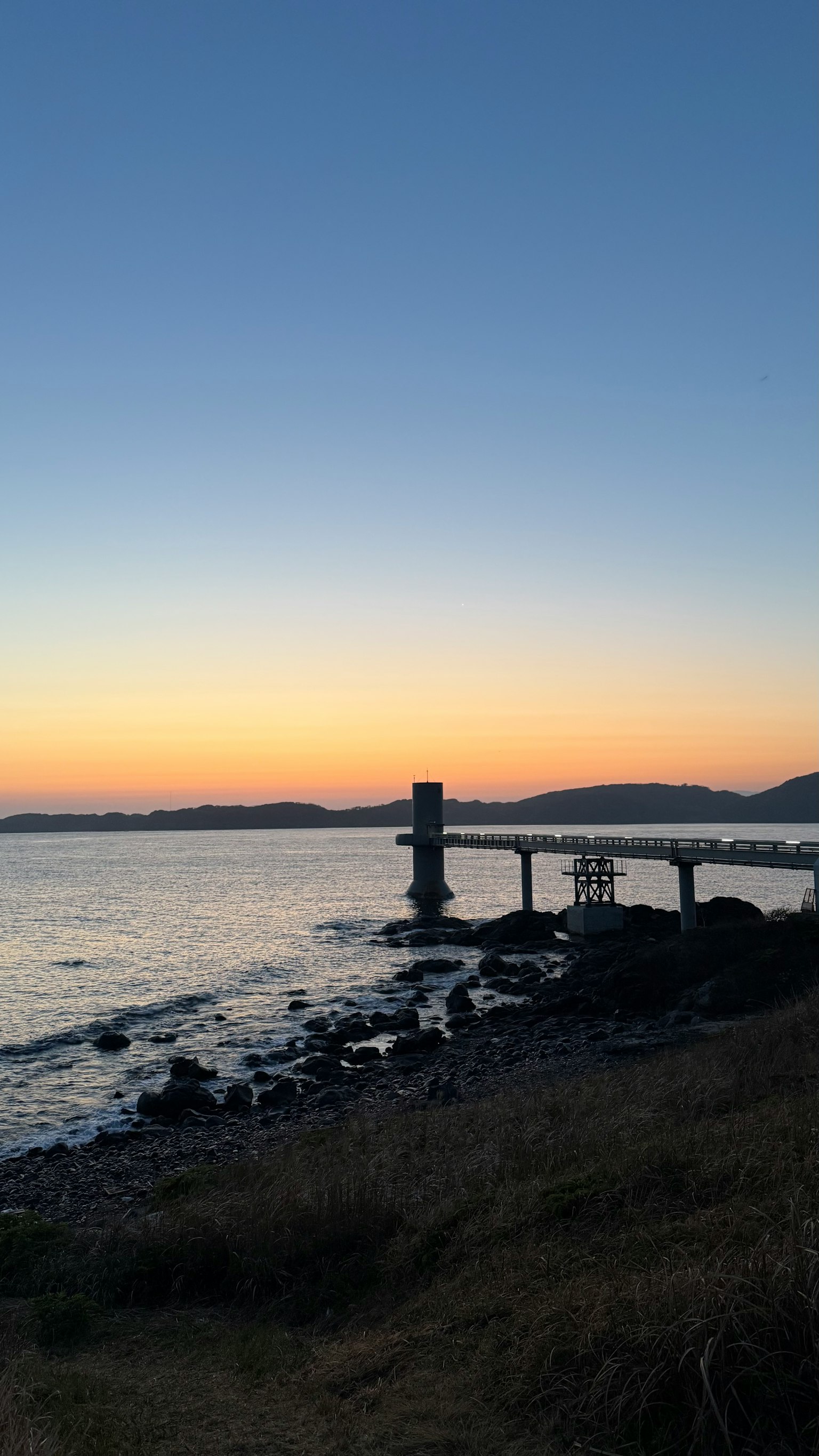 海岸日落，包含码头和温柔的海浪