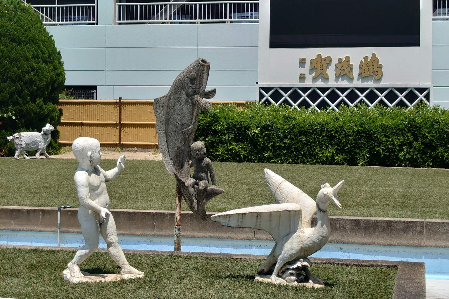 Esculturas en un parque que presentan una figura blanca y esculturas de animales