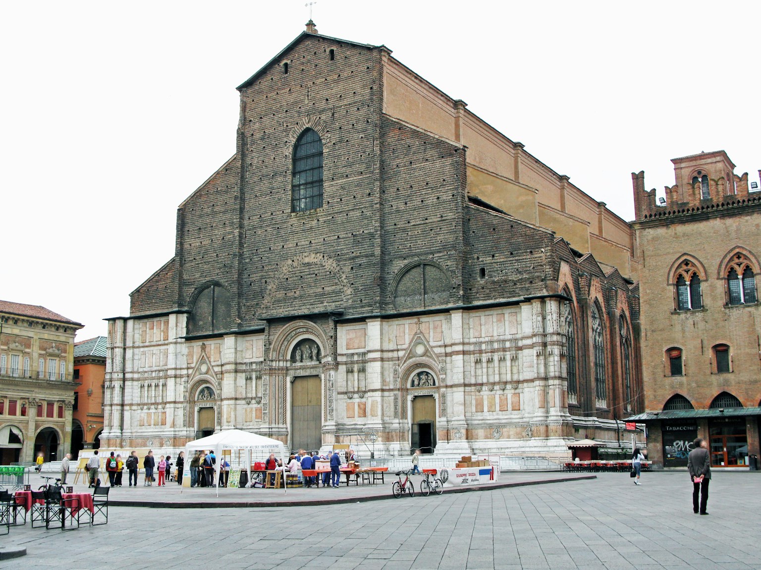 Exterior view of San Petronio Basilica in Bologna with people and tents