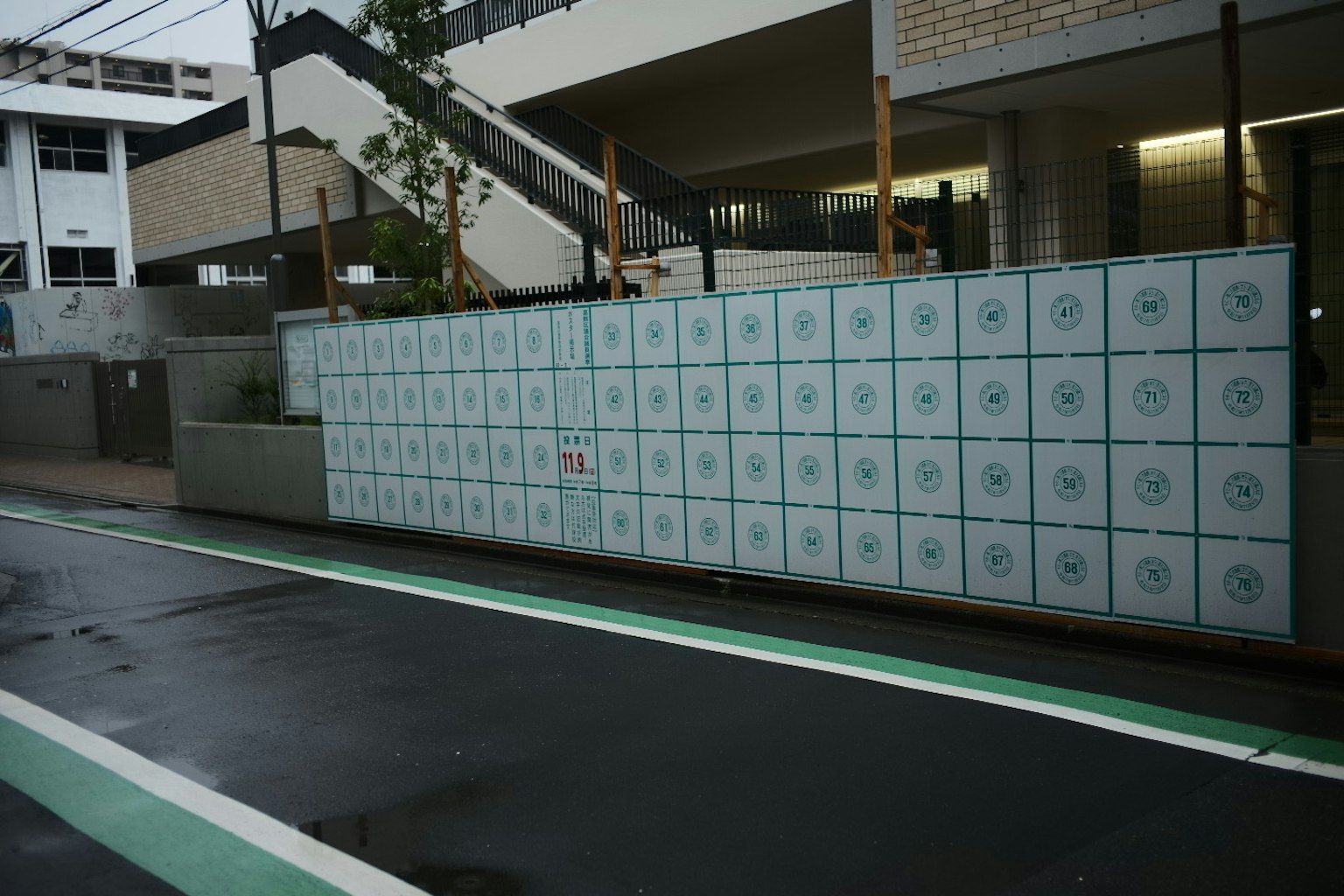 現代的な建物の前にある郵便ボックスの壁 緑の自転車道が横にある