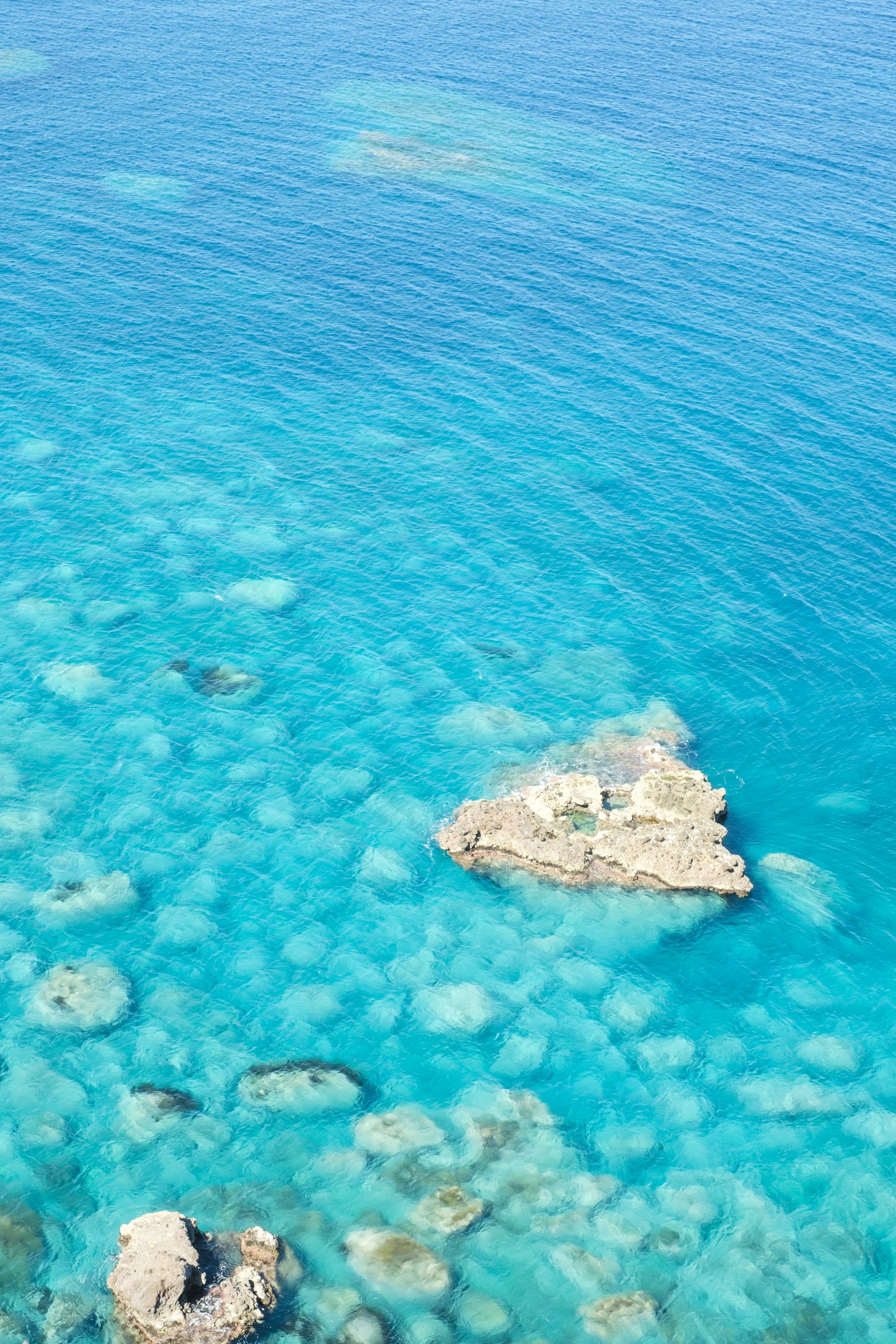 Oceano blu chiaro con rocce visibili
