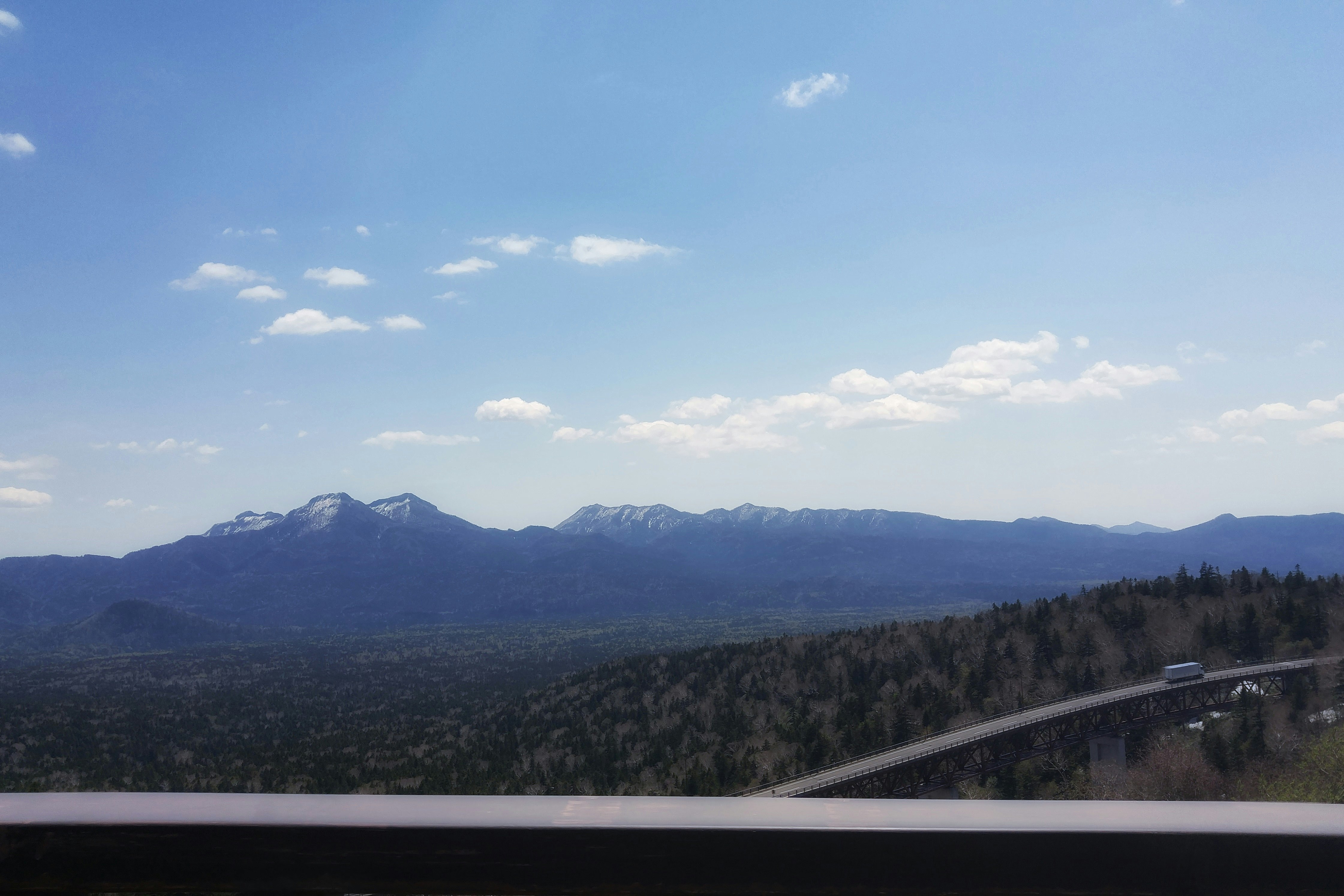 車窓から見える山並みと青空の風景