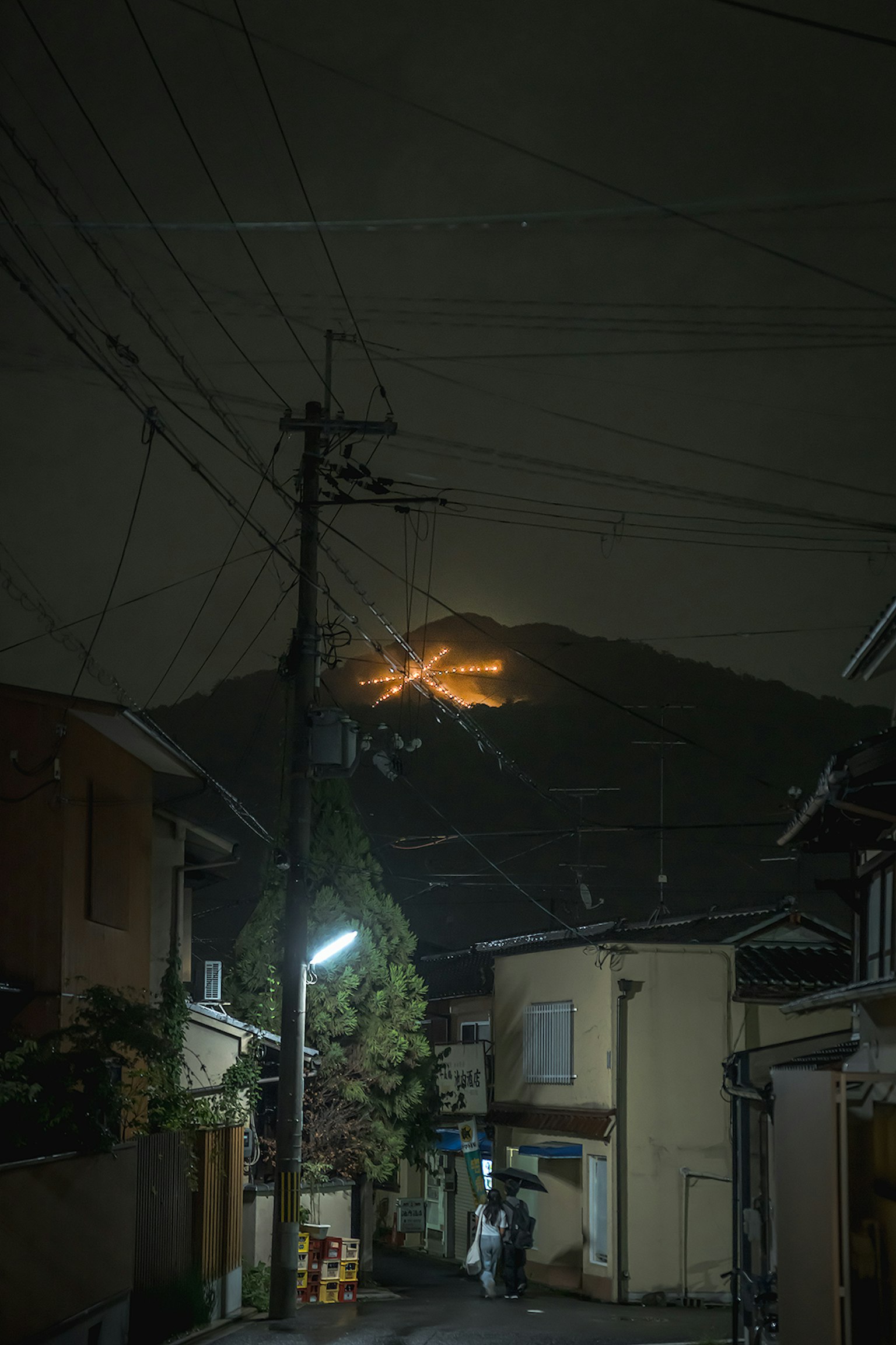 夜間街道場景與山上發光的光
