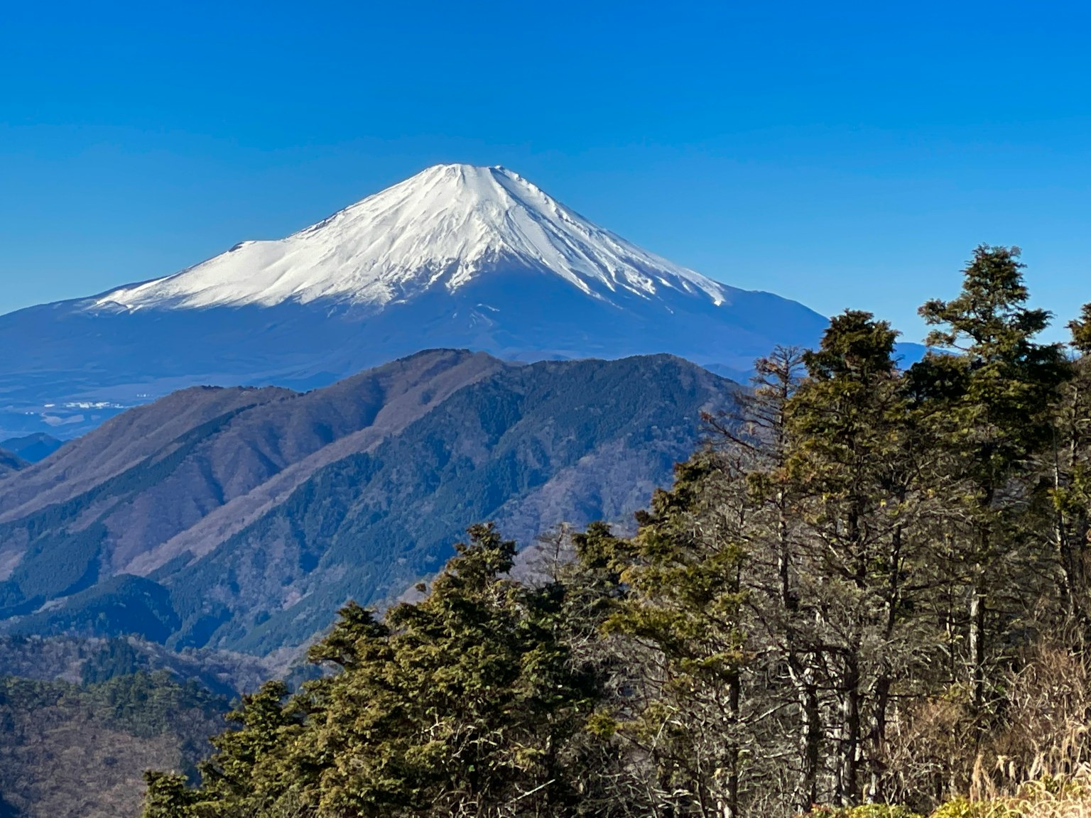 雪覆蓋的富士山與周圍的山脈和晴朗的藍天