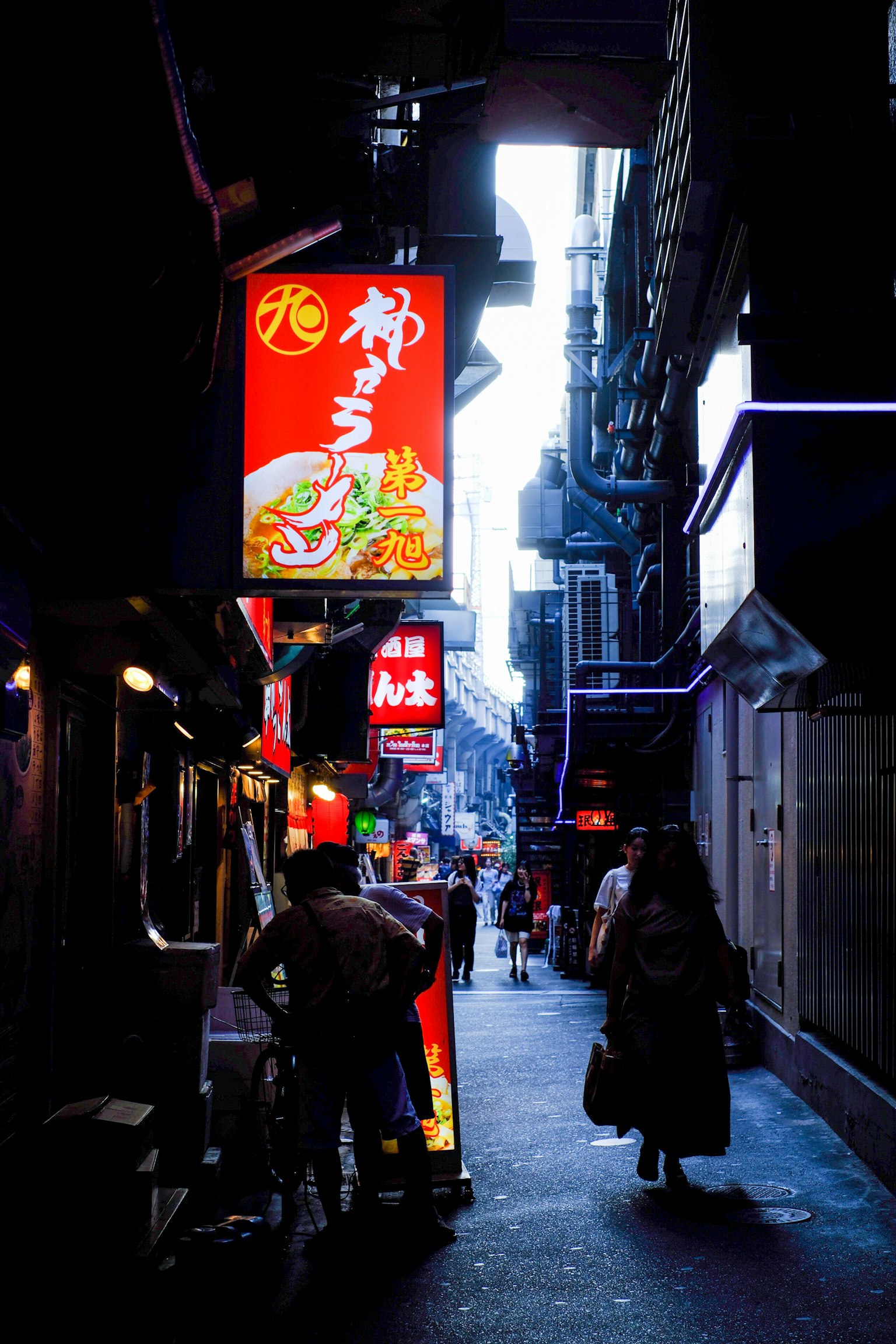 東京狹窄小巷中的餐廳招牌和行人