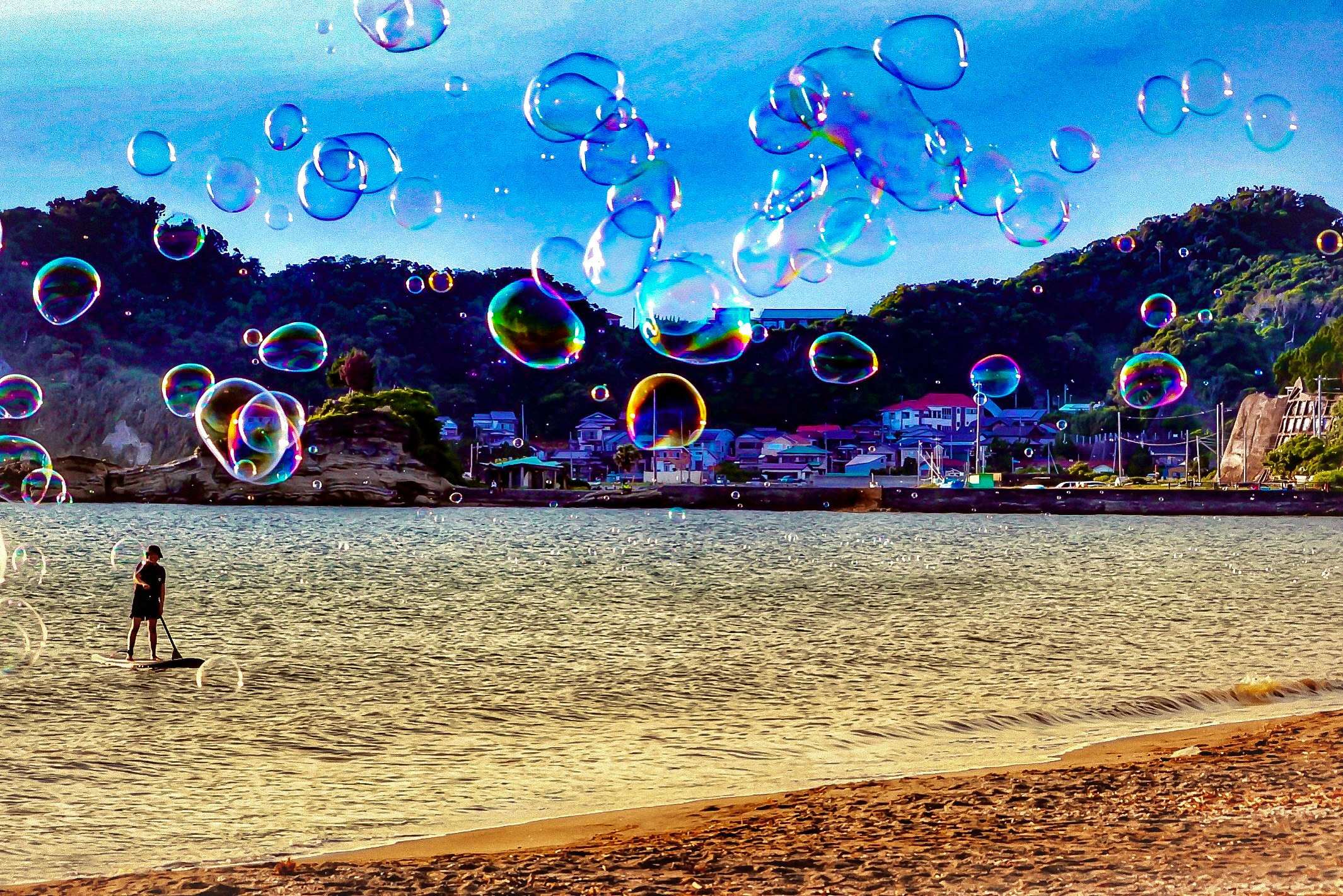 Bong bóng xà phòng bay lơ lửng trên khung cảnh hoàng hôn bên bờ biển