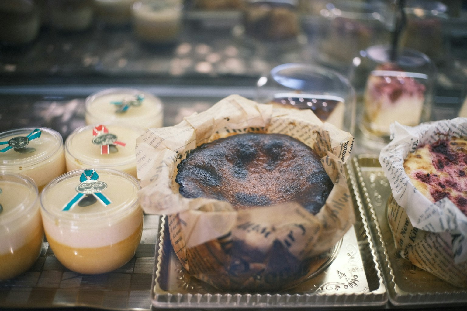Vitrine mit einem verbrannten Kuchen und bunten Cremedesserts mit dekorativen Toppings