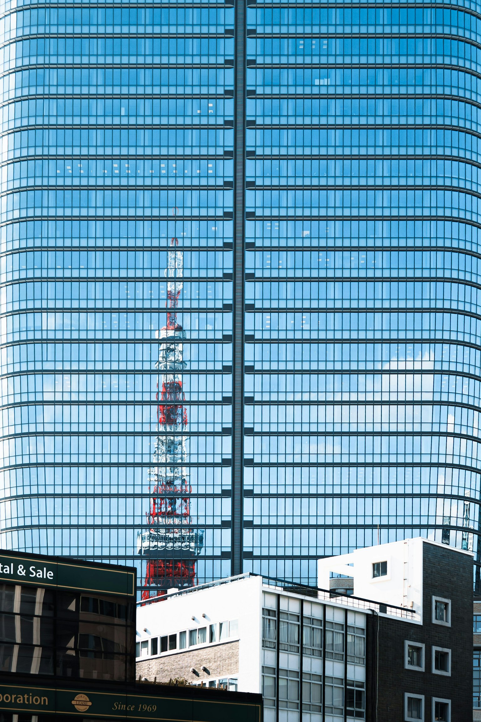 Reflet de la Tour de Tokyo sur un bâtiment en verre