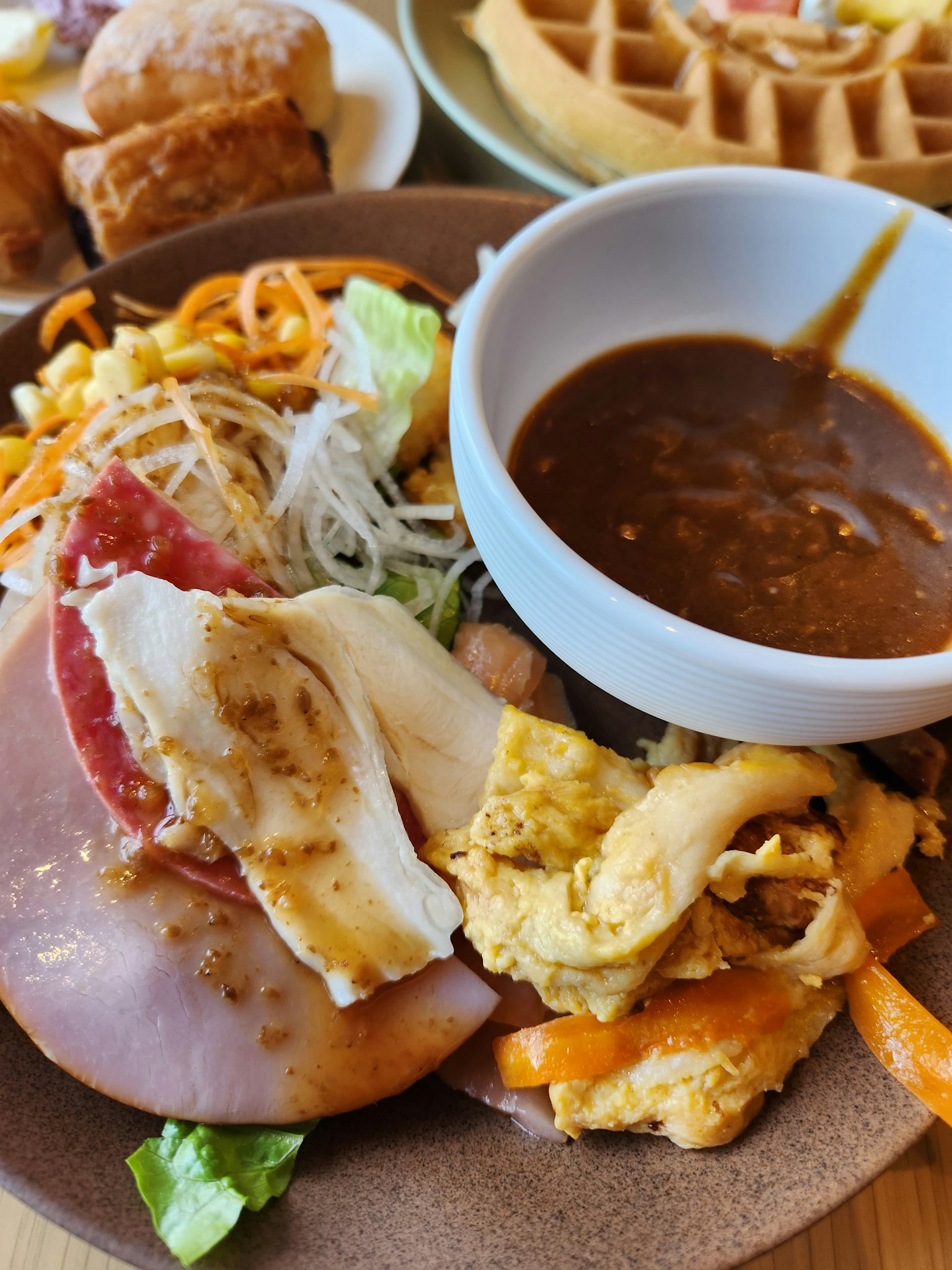 Một đĩa có salad, trứng, giăm bông và sốt