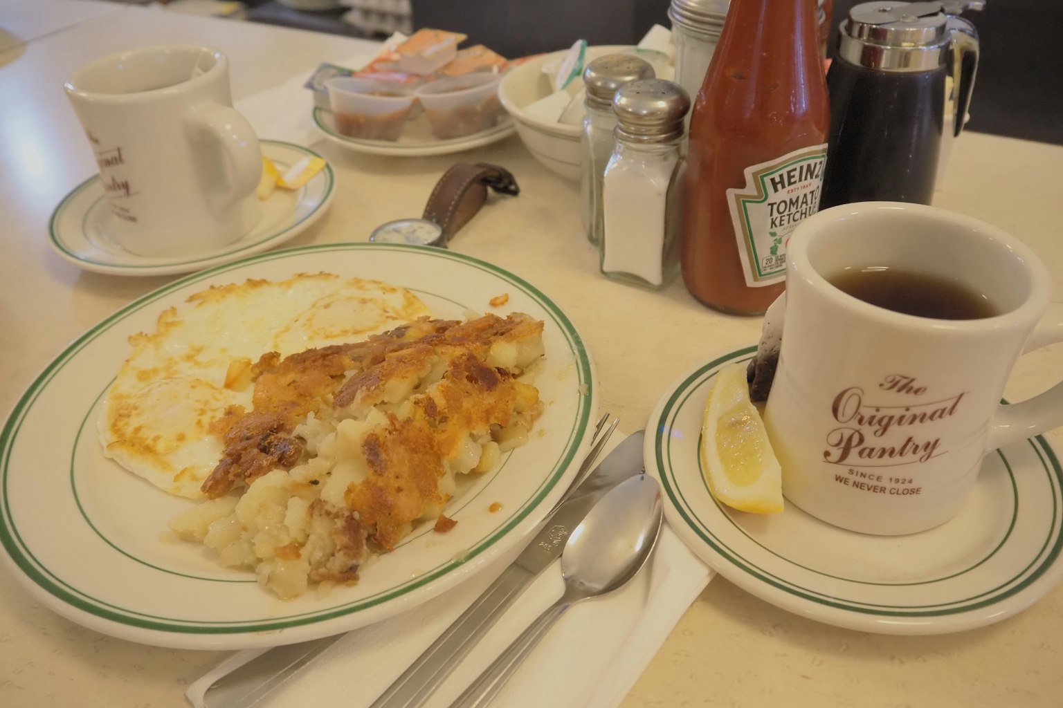 Frühstücksteller mit knusprigen Hash Browns und einer Tasse Kaffee auf dem Tisch