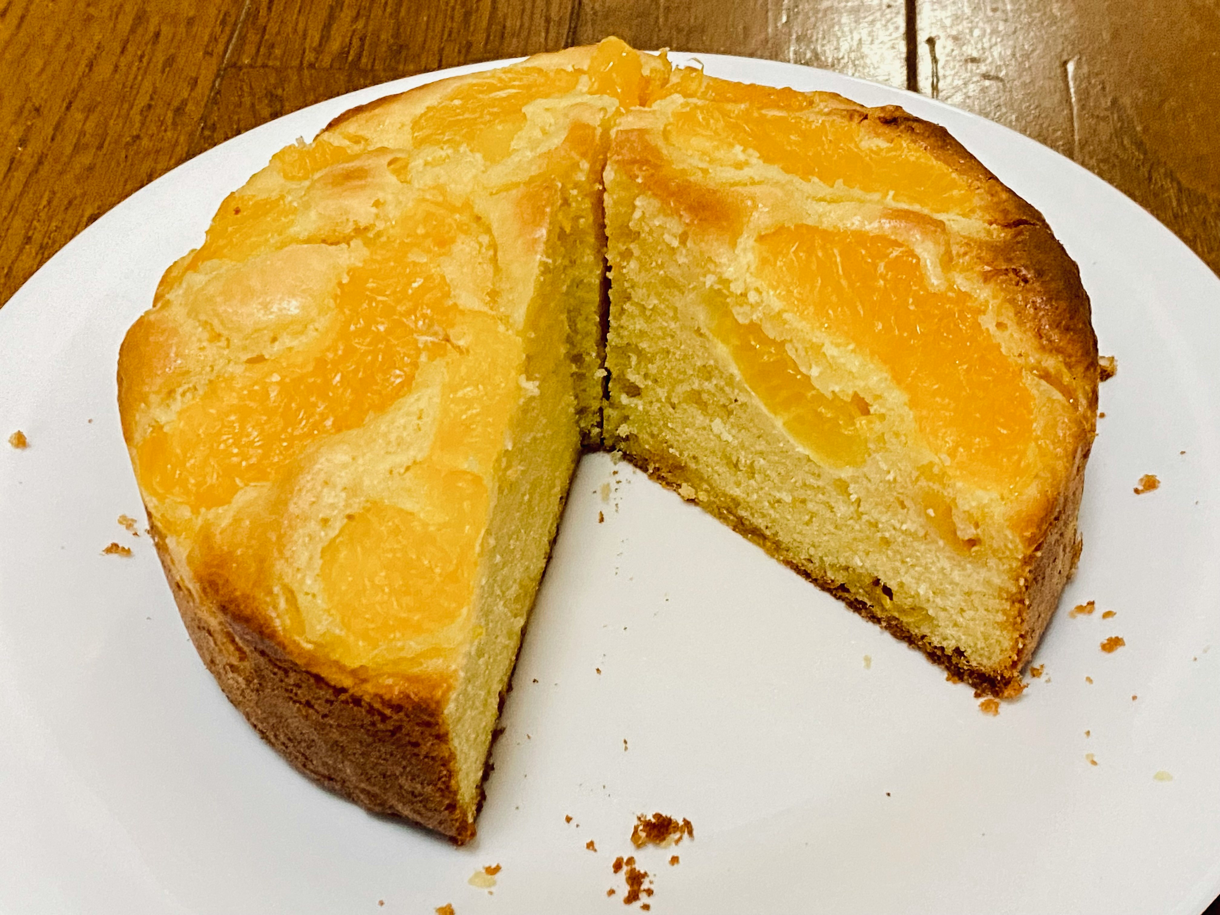 gros plan d’un gâteau à la mandarine tranché sur une assiette blanche