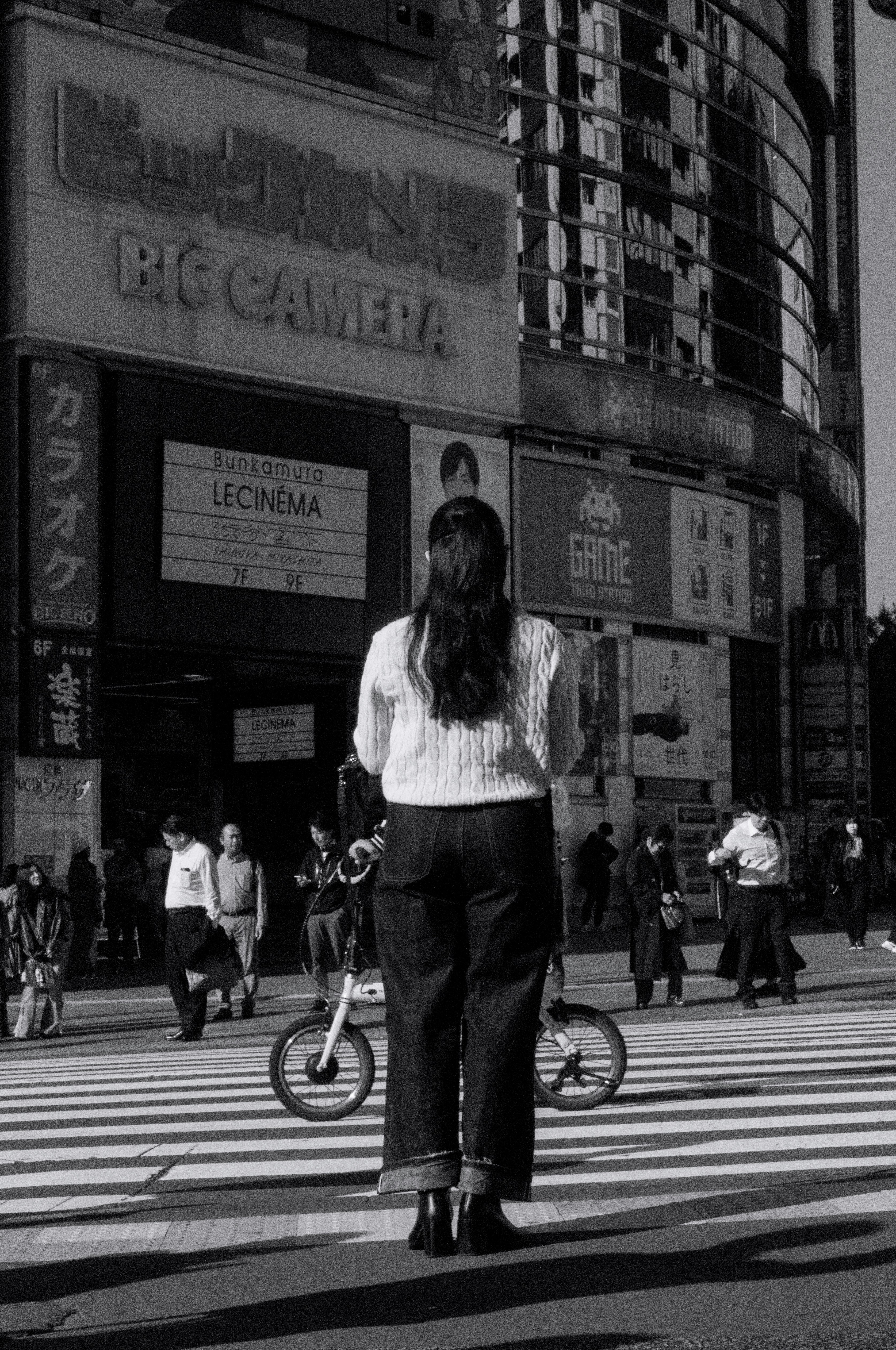交差点で自転車の前に立つ女性