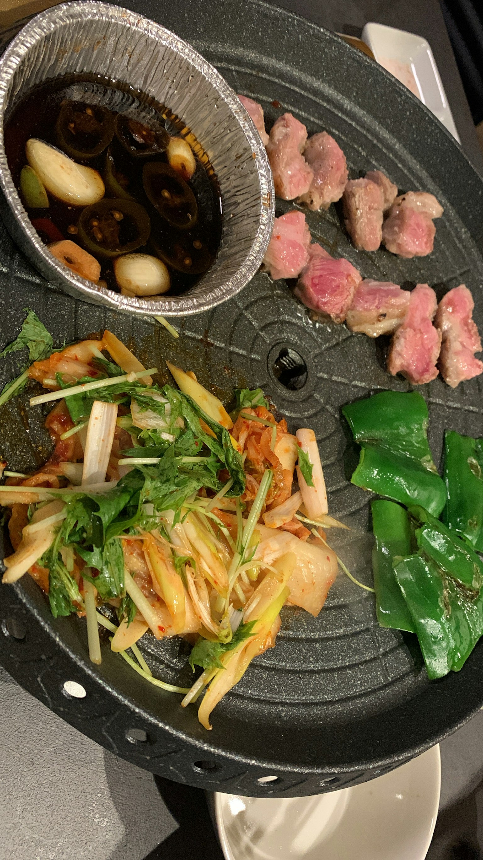 Grilled meat and fresh vegetables arranged on a barbecue plate