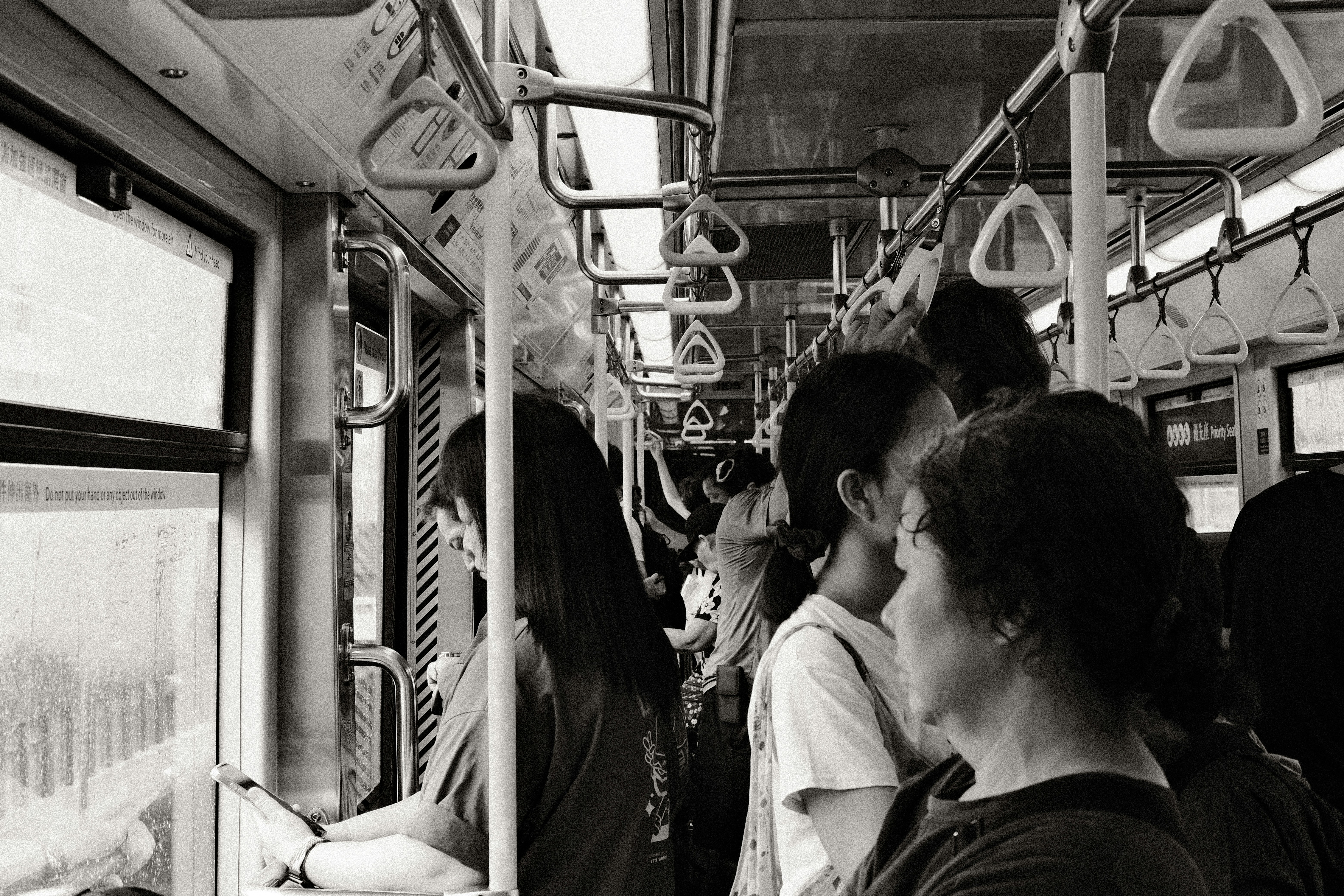 車内で手すりにつかまり会話する乗客のある電車の風景