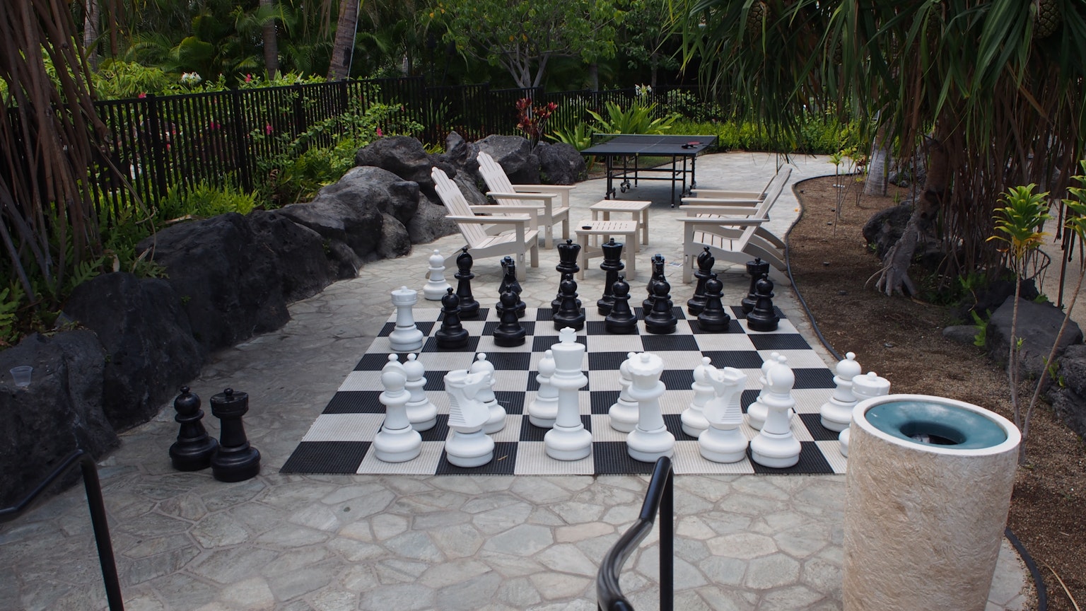 大型户外国际象棋棋盘，黑白棋子置于一个放松的空间