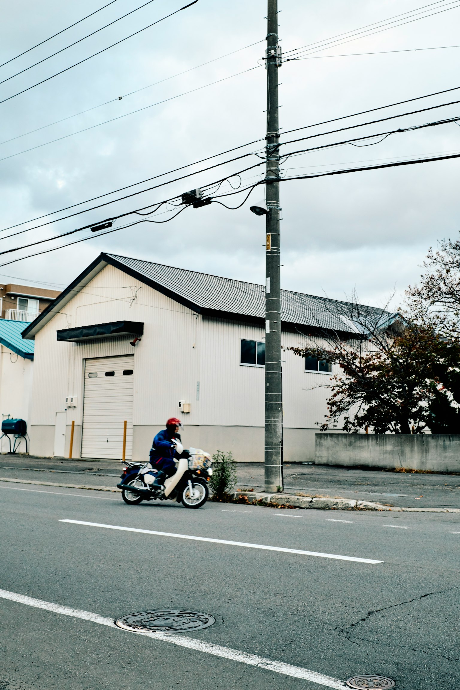 Image of a man riding a motorcycle in front of a white house