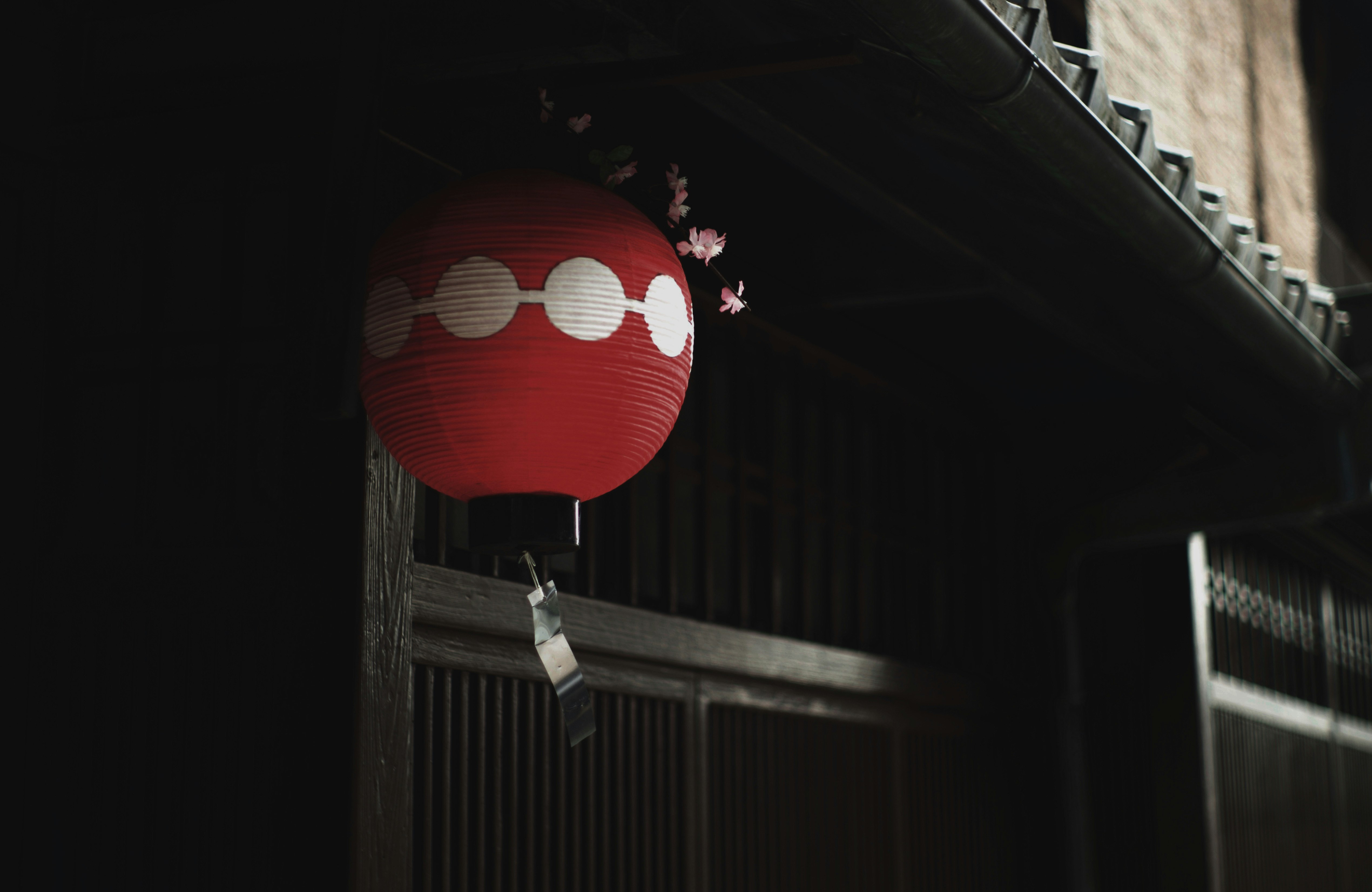 red lanterns hanging under a wooden eave in Kamishichiken alley