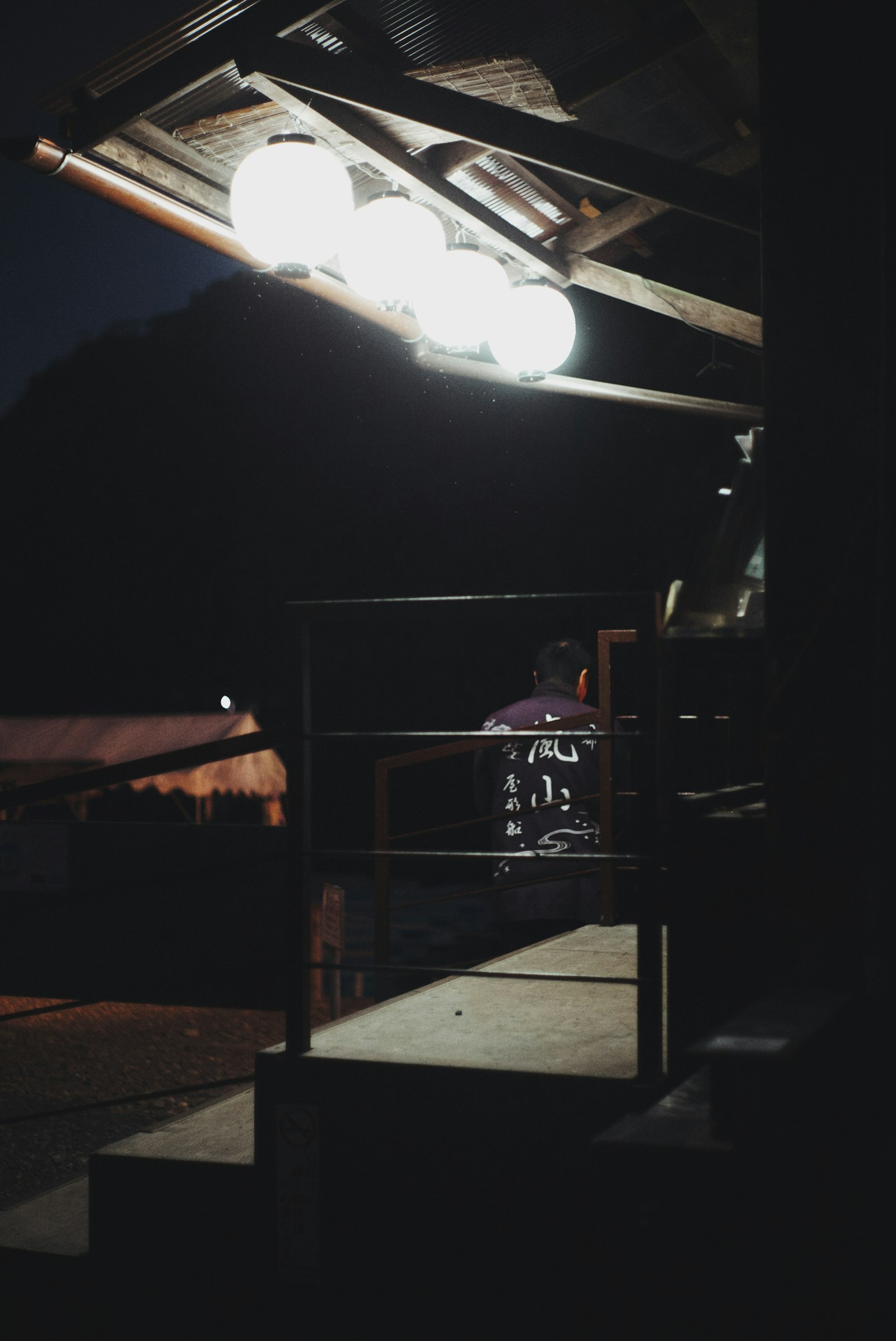 Bild mit einer Außentreppe, die nachts von hellen Lichtern beleuchtet wird