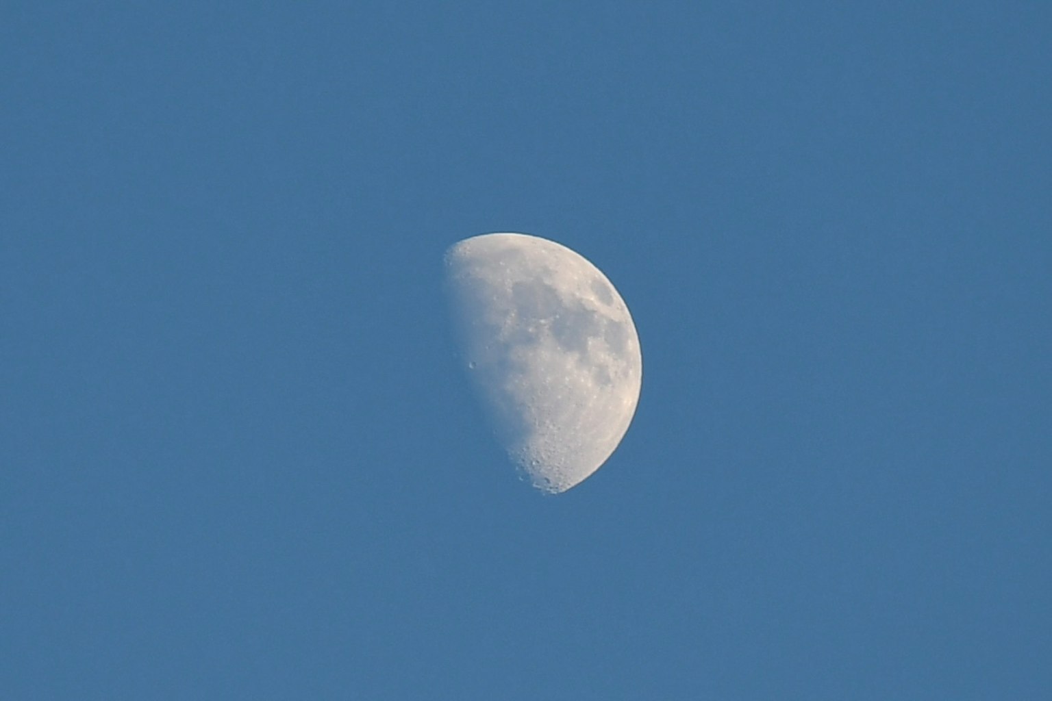 Primer plano de una media luna en un cielo azul