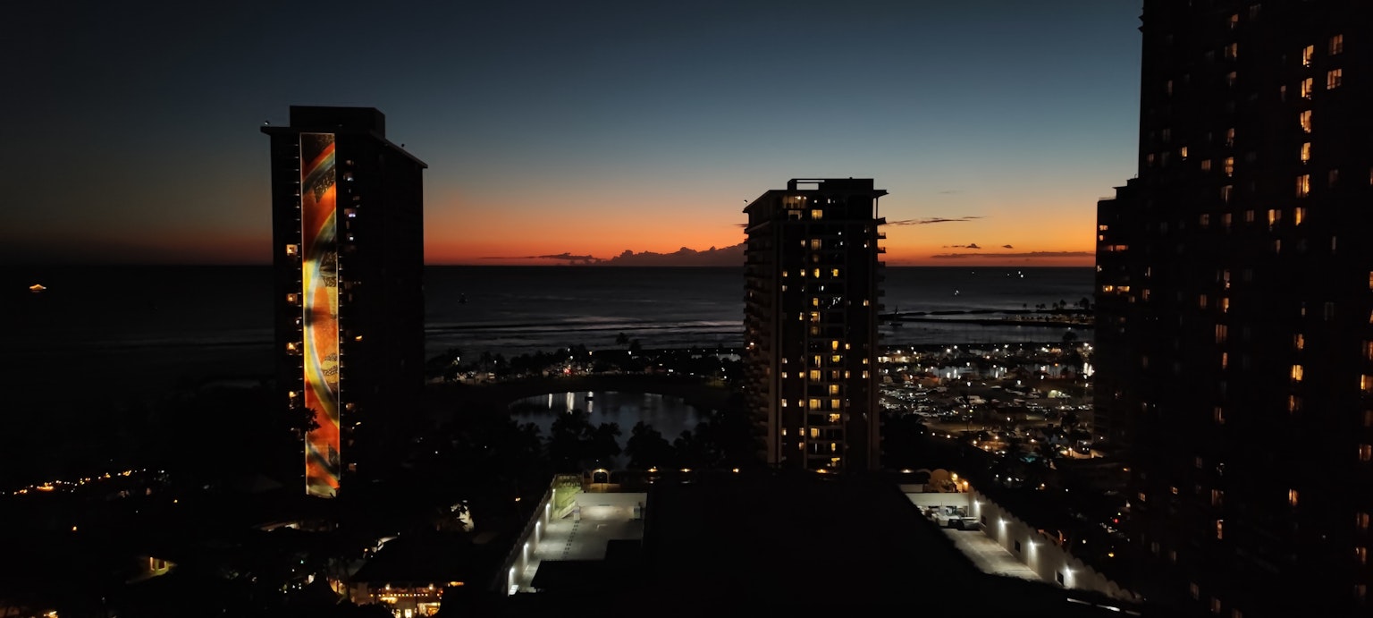 Night view of buildings and sunset over the sea