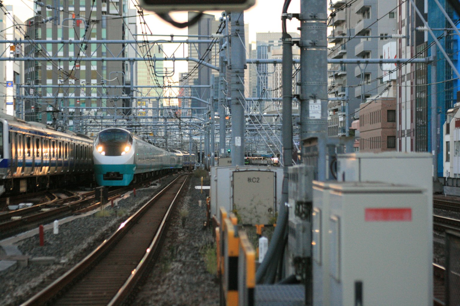 Cảnh đường sắt đô thị với Shinkansen đang tiến lại gần giữa các tòa nhà cao tầng